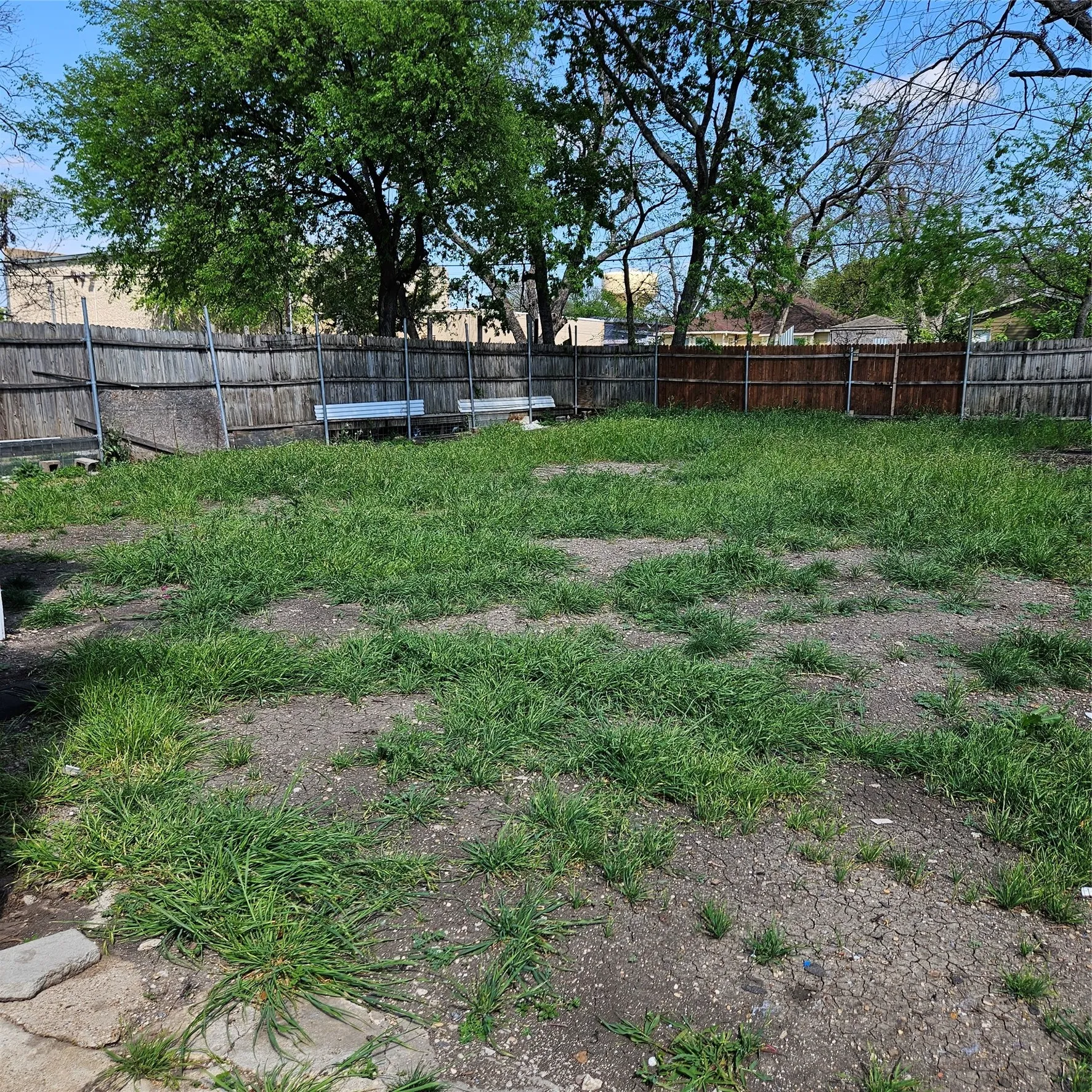 Spacious backyard featuring a combination of grass and exposed earth