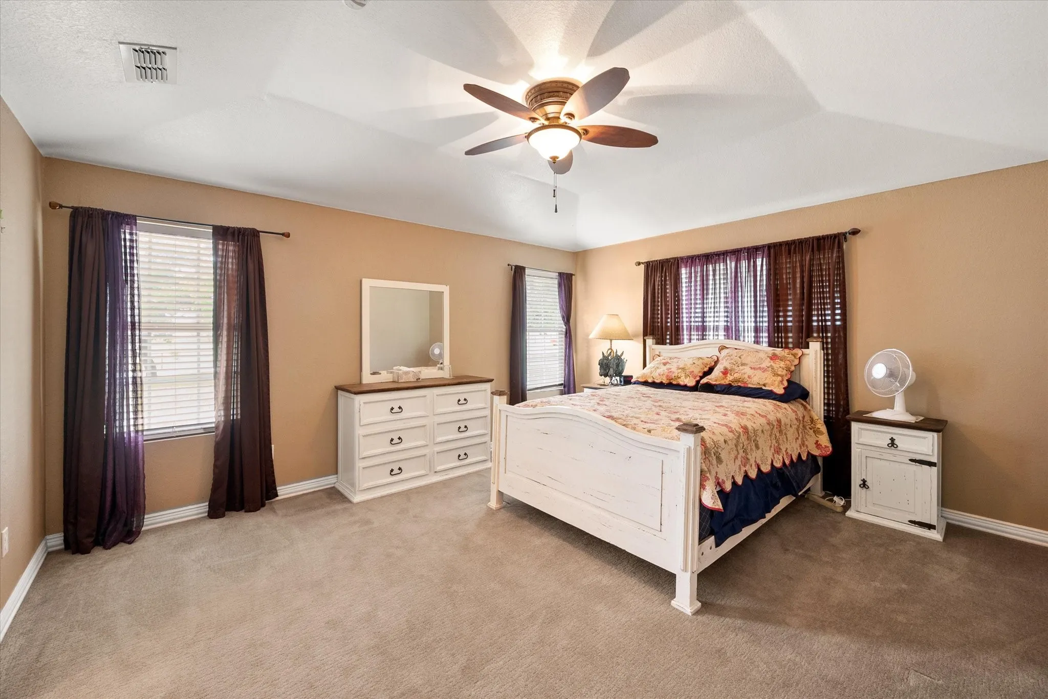 Carpeted room featuring a vaulted ceiling with a ceiling fan
