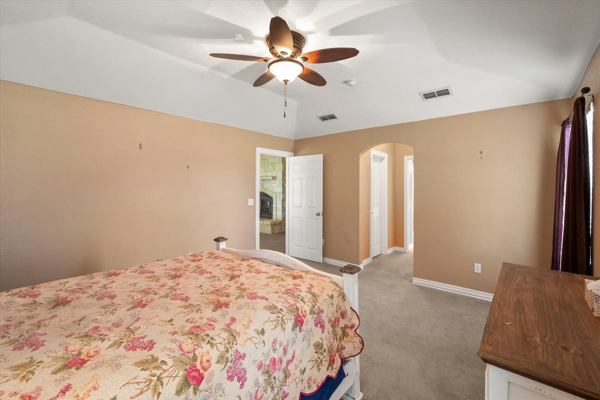 Room featuring a tray ceiling with a ceiling fan, neutral-toned walls, and carpet flooring