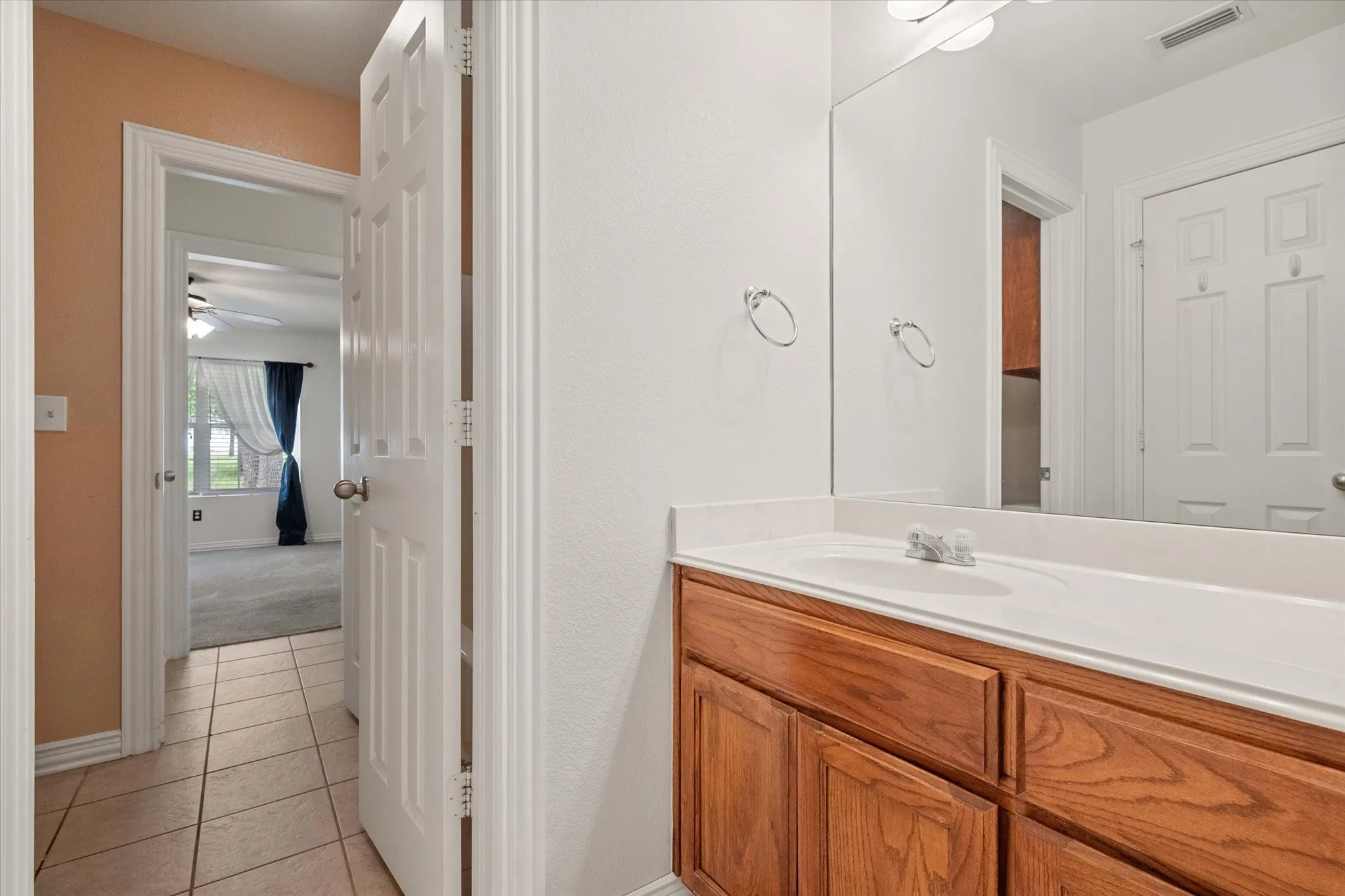 Bathroom vanity featuring a light-colored countertop, integrated sink, and wood-finish cabinetry