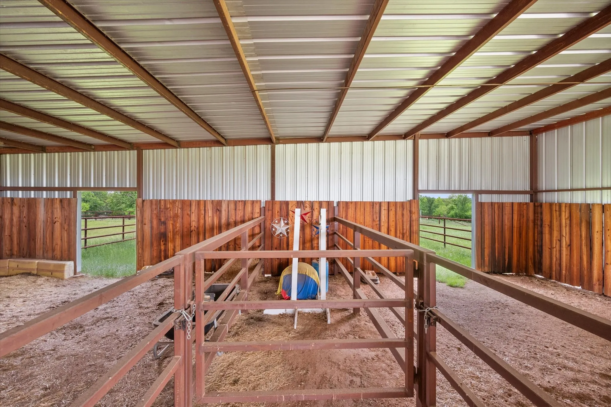 Spacious barn interior featuring metal roofing and structural beams
