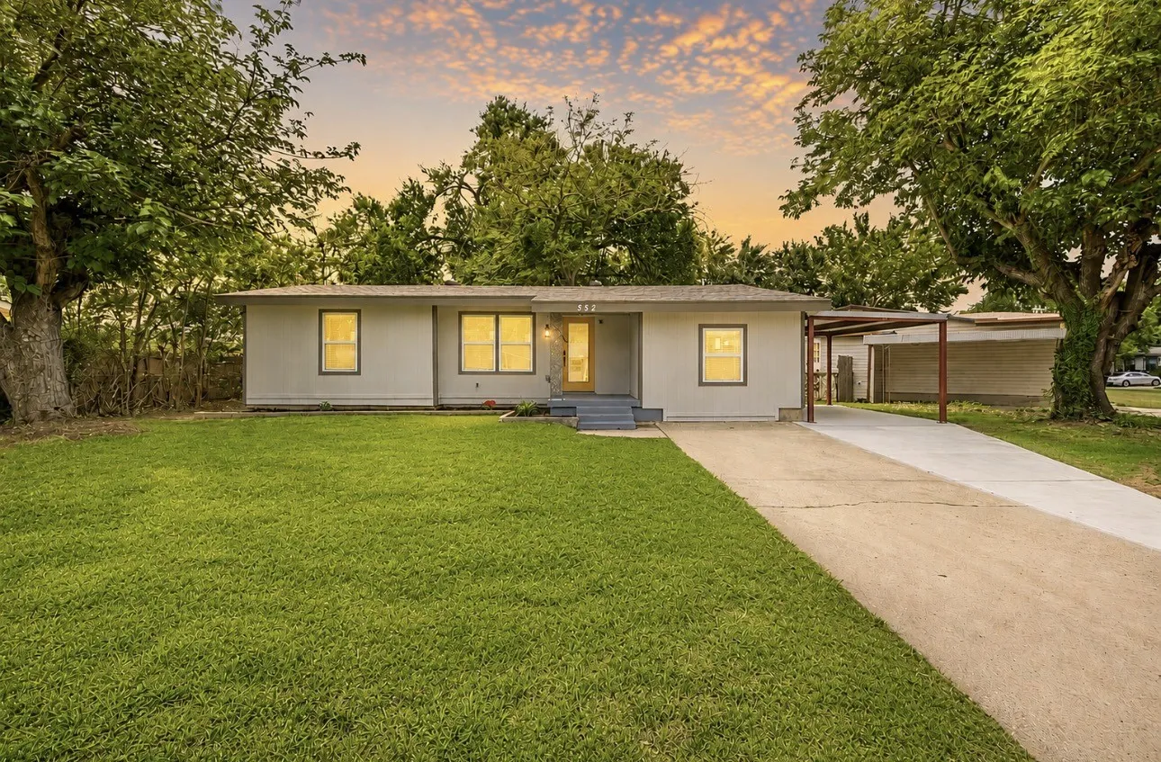 Single-story residence featuring a front lawn and a long driveway