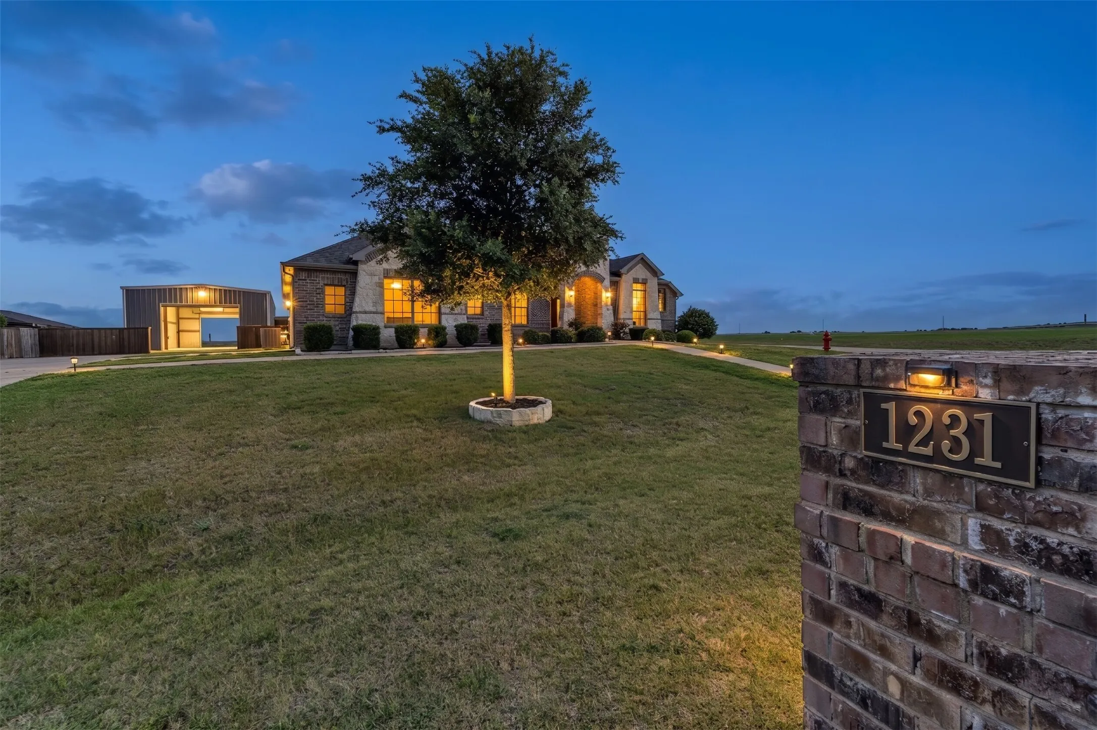 Brick and stone facade residence with an illuminated address plaque
