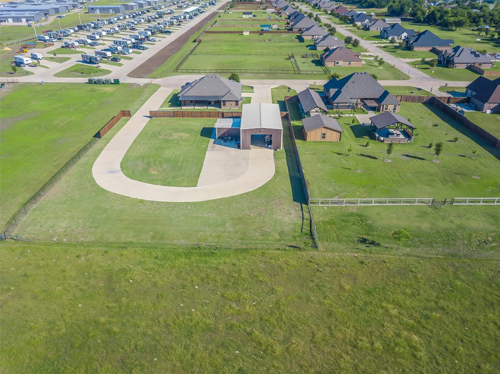 Expansive property featuring a circular drive, a large metal outbuilding, and a separate storage shed