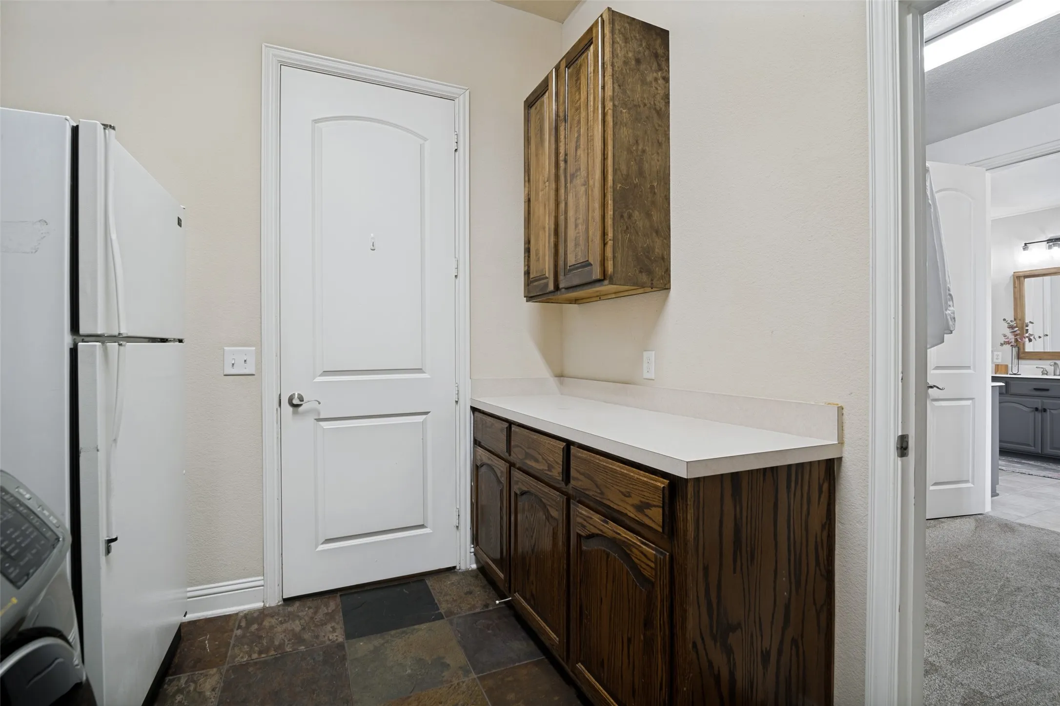 Additional view in spacious laundry room that shows extra counter space and cabinetry