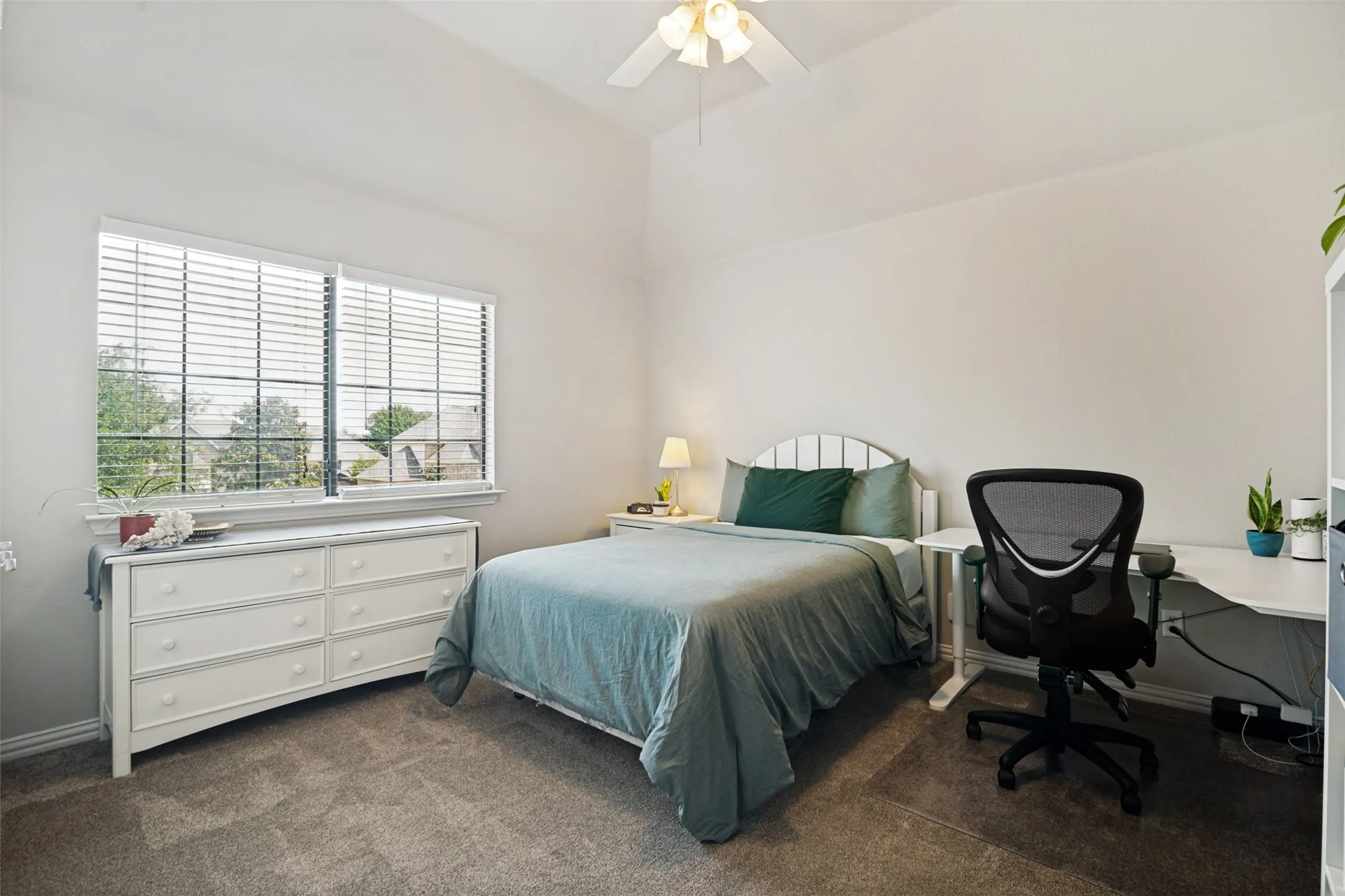 Bedroom with vaulted ceiling, ceiling fan, and double window featuring horizontal blinds