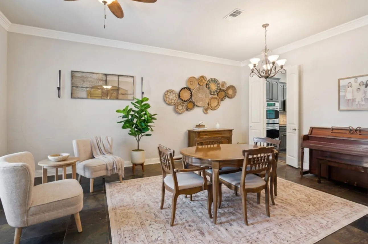 Virtually staged. Formal dining space featuring dark flooring, crown molding, and a five-light chandelier