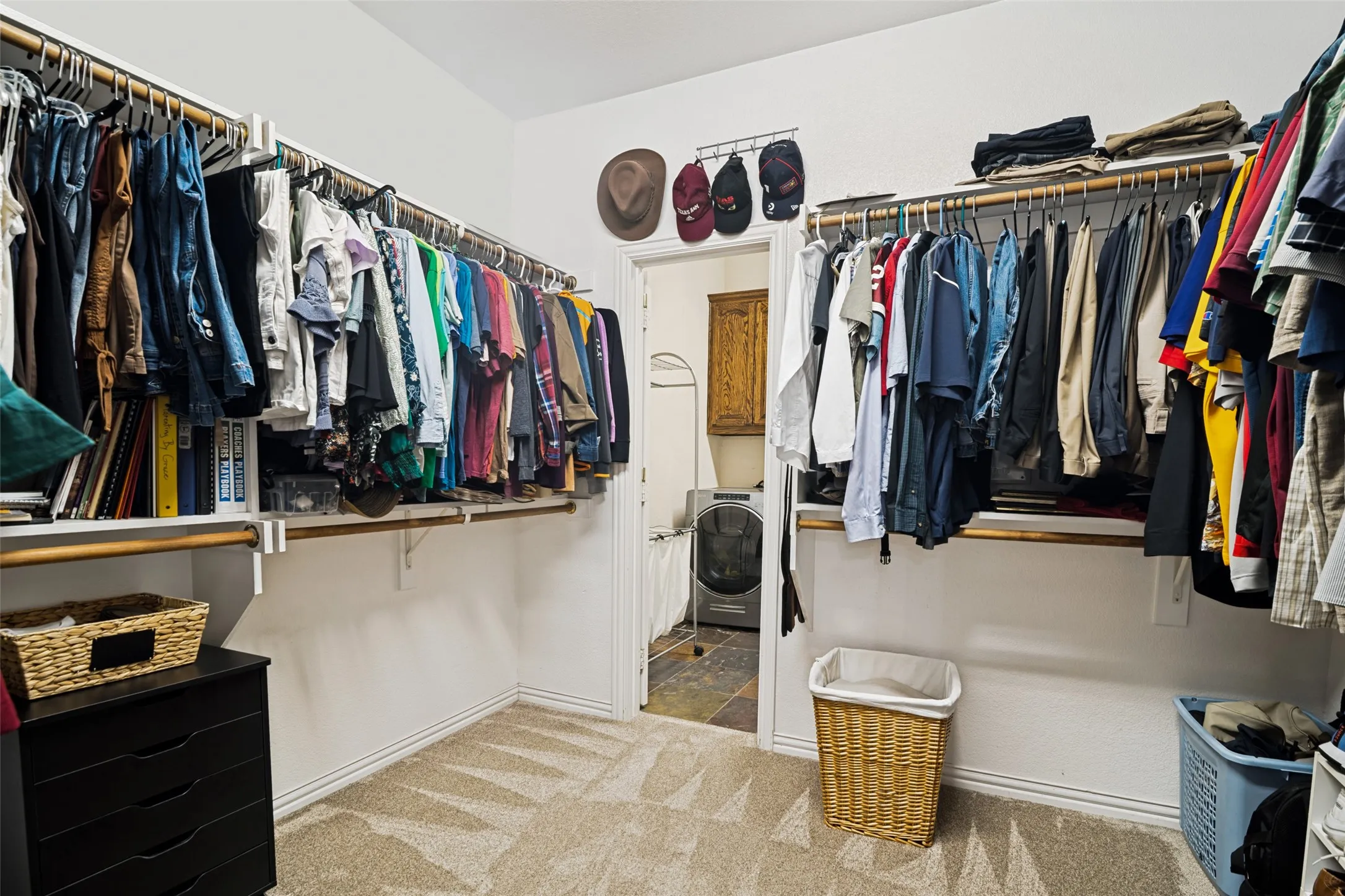 Walk-in closet with carpeted flooring, white walls, and extensive built-in shelving