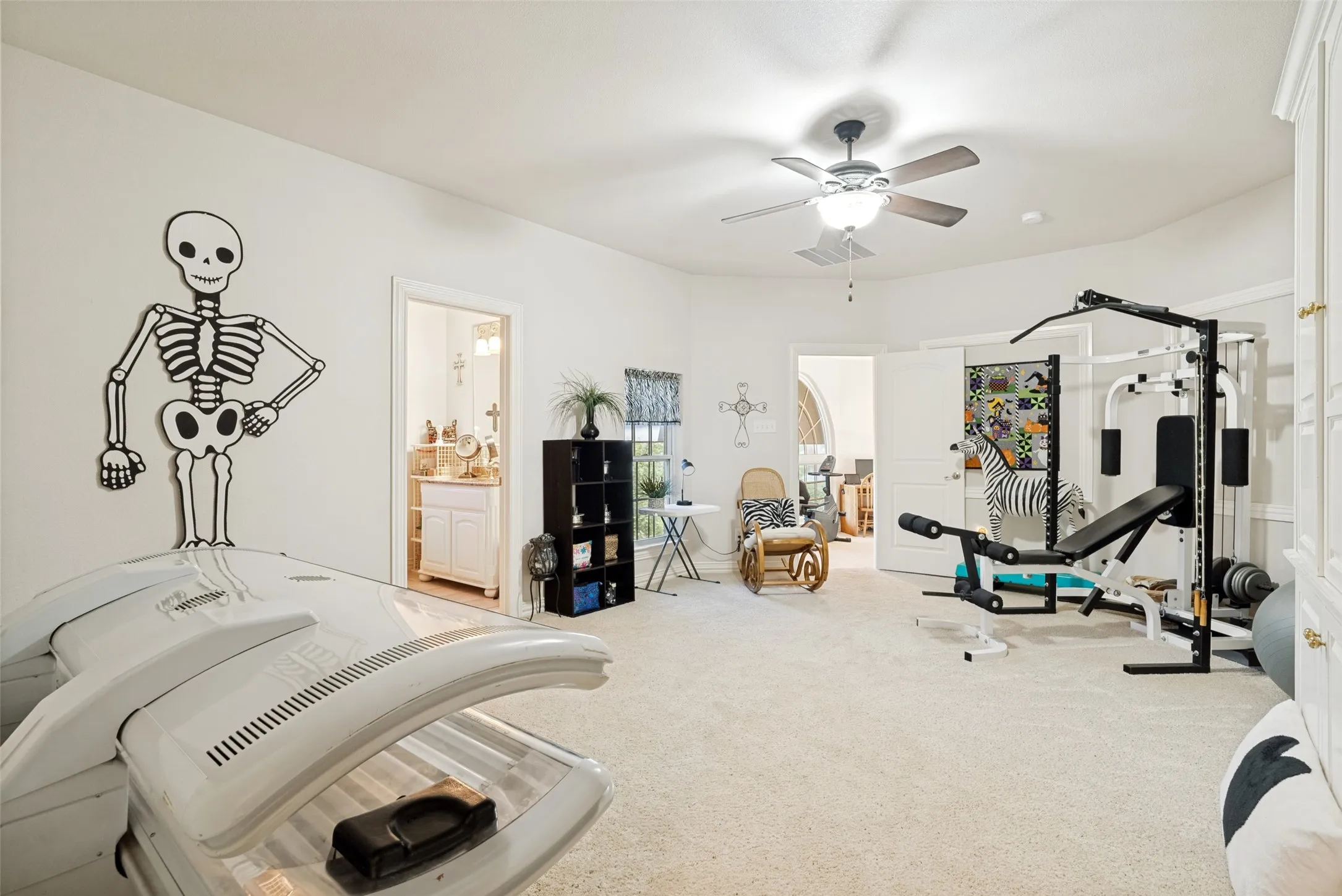 Spacious room with plush carpeting, featuring a ceiling fan with integrated lighting