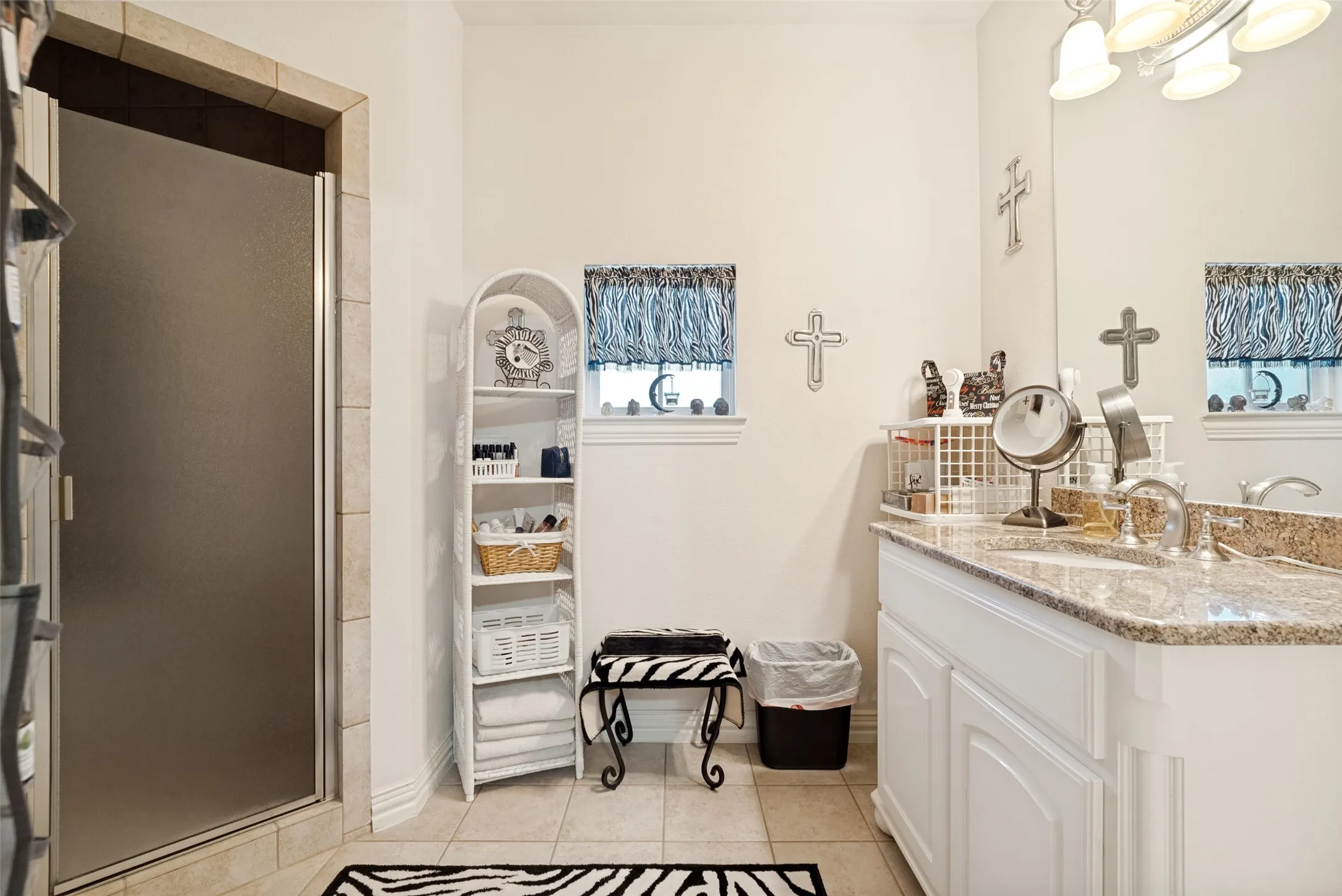 Shower enclosure with frosted glass door, tile surround, and tile flooring