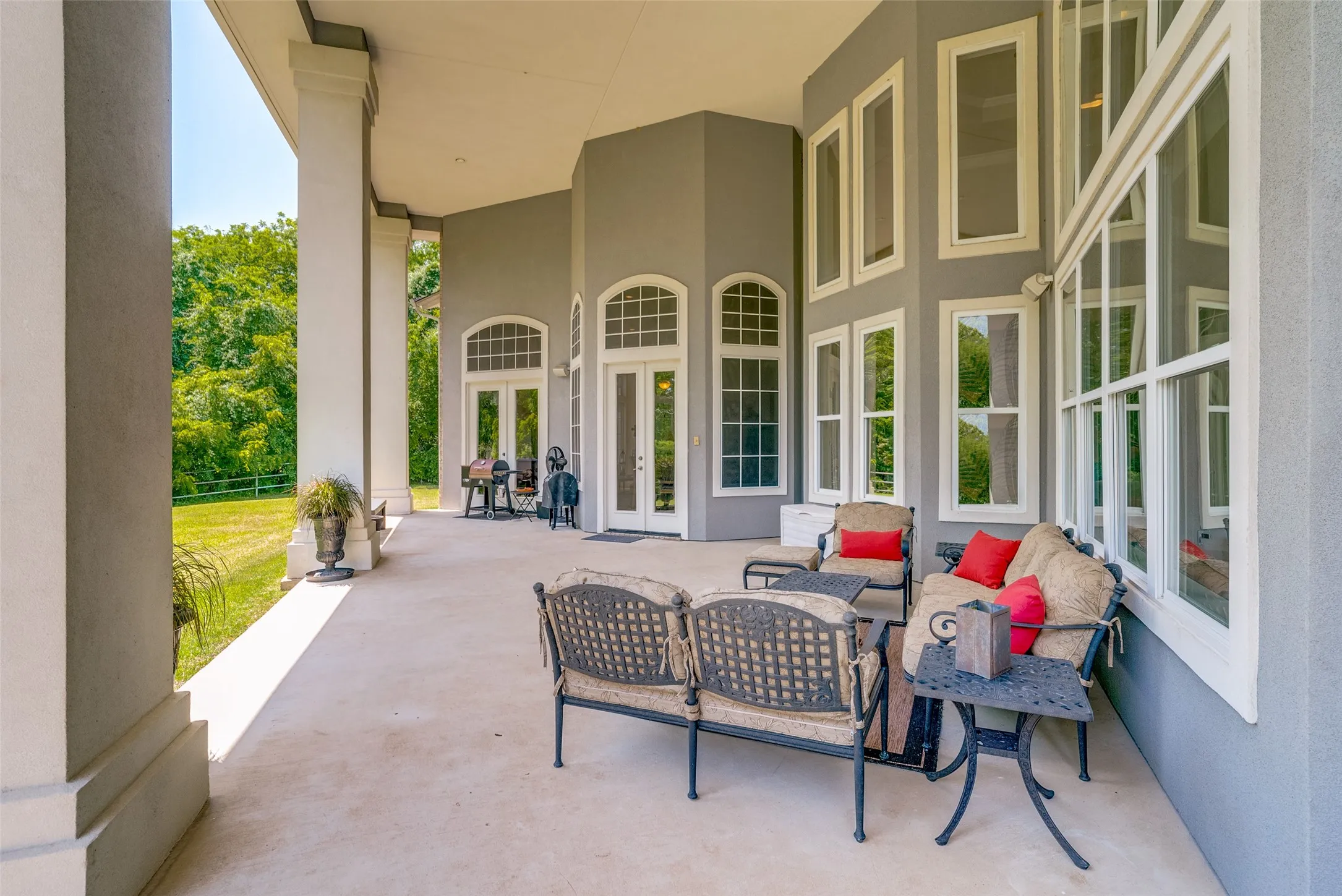 Covered concrete patio featuring substantial architectural columns