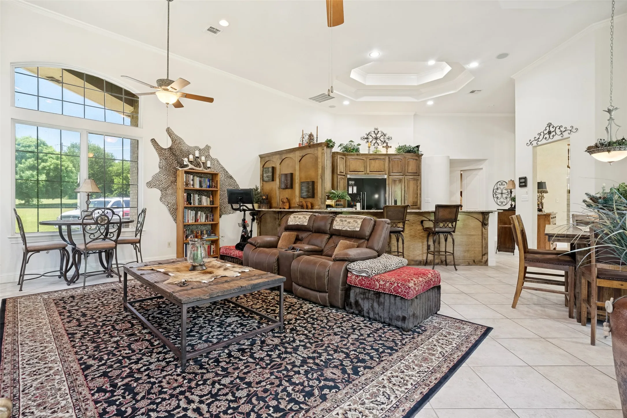 Spacious living area featuring a vaulted ceiling and a prominent large arched window with grid detailing