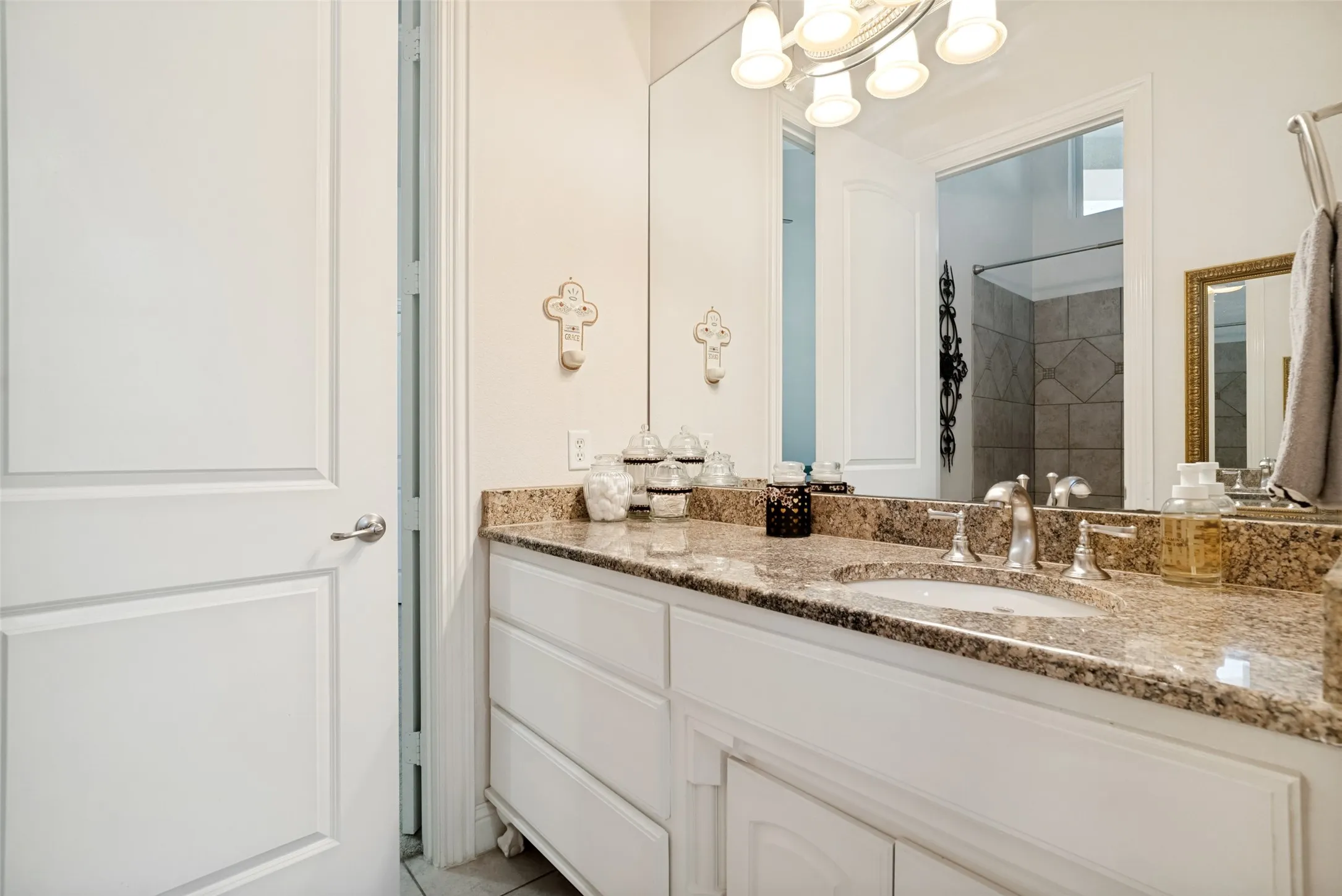 Bathroom vanity featuring a granite countertop with an undermount sink and chrome fixtures