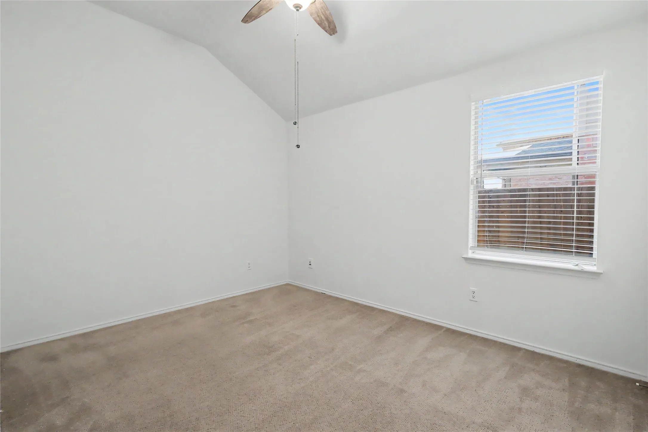 Room featuring a vaulted ceiling and neutral carpet flooring