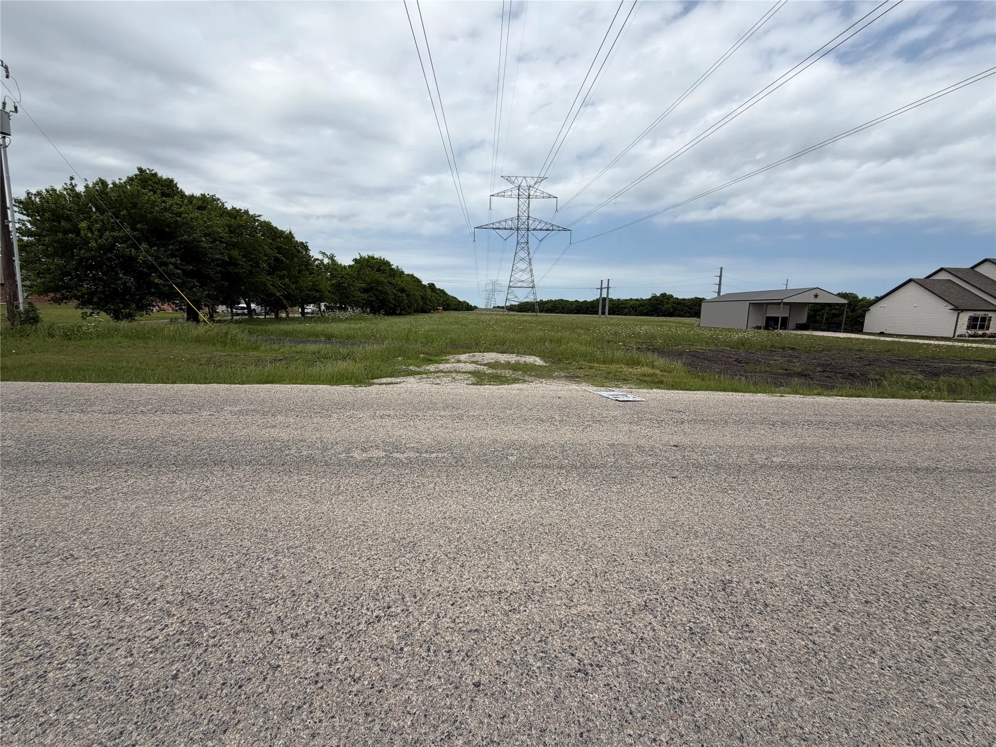 Roadside frontage with a grassy undeveloped lot,  shaped in an L   the land goes behind the house in the picture