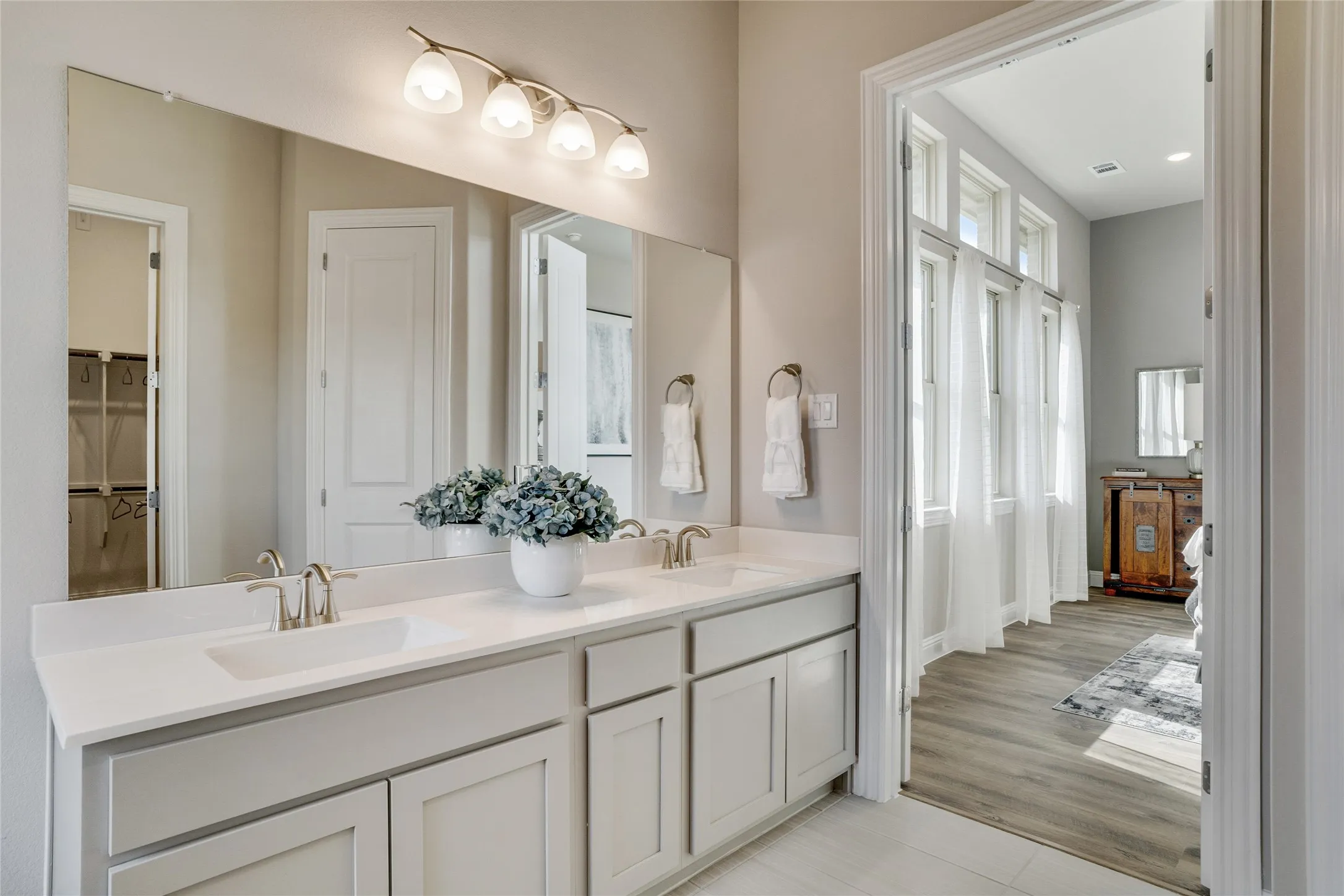 Double vanity with light cabinetry and solid surface countertops