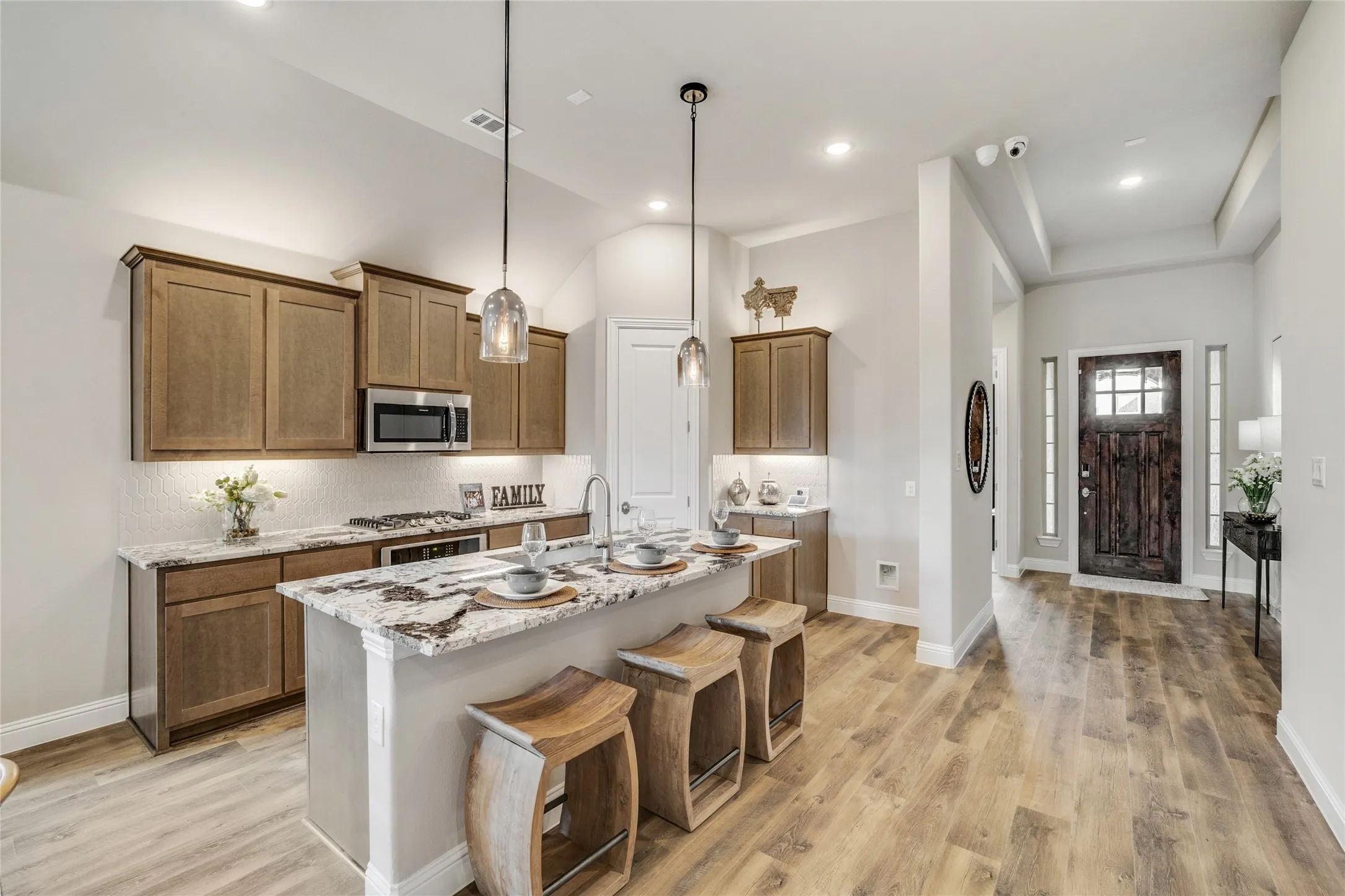 Kitchen island featuring a stone countertop and pendant lighting