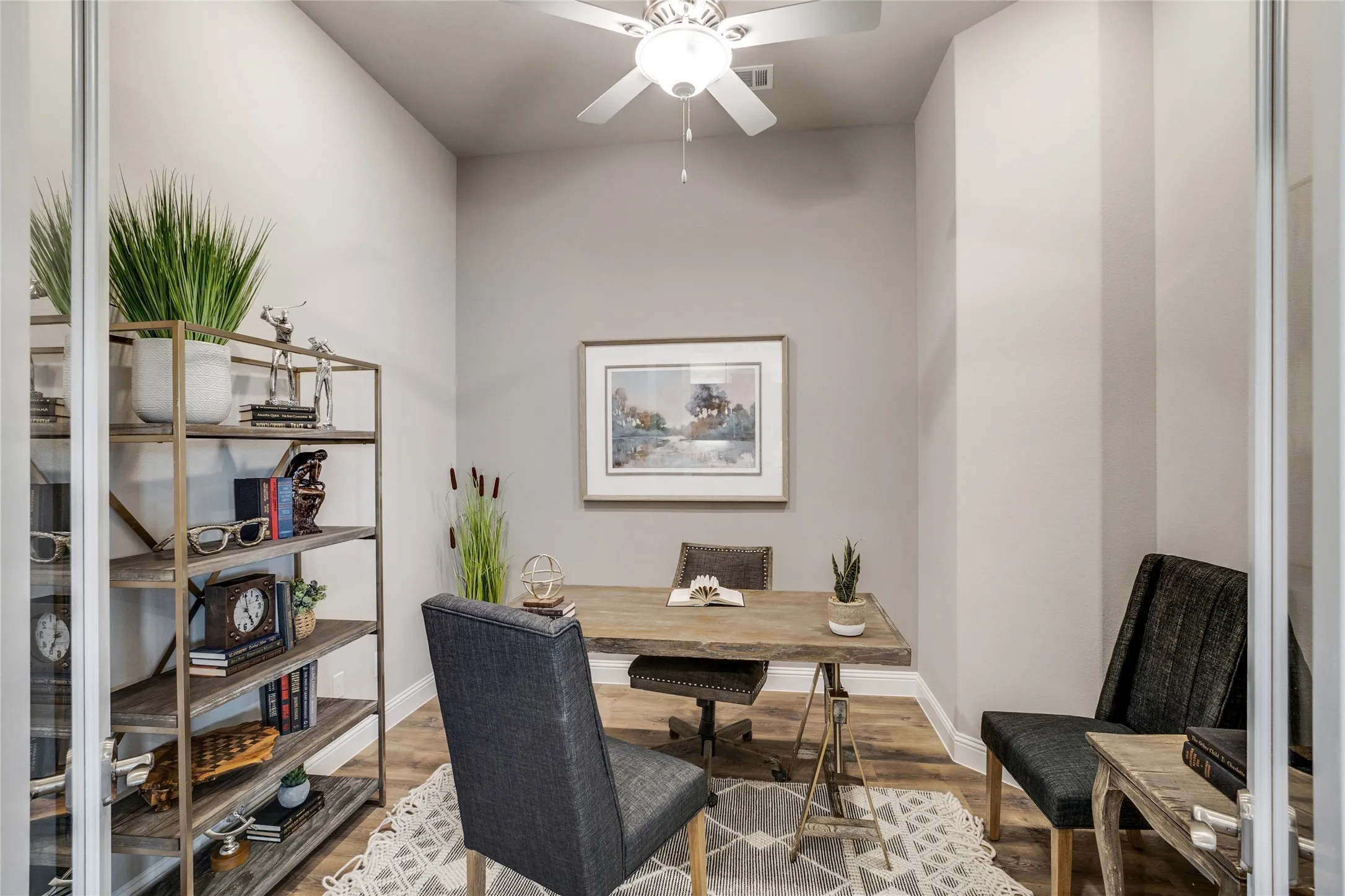 Dedicated room featuring wood-finish flooring, a ceiling fan with integrated lighting, and neutral wall tones