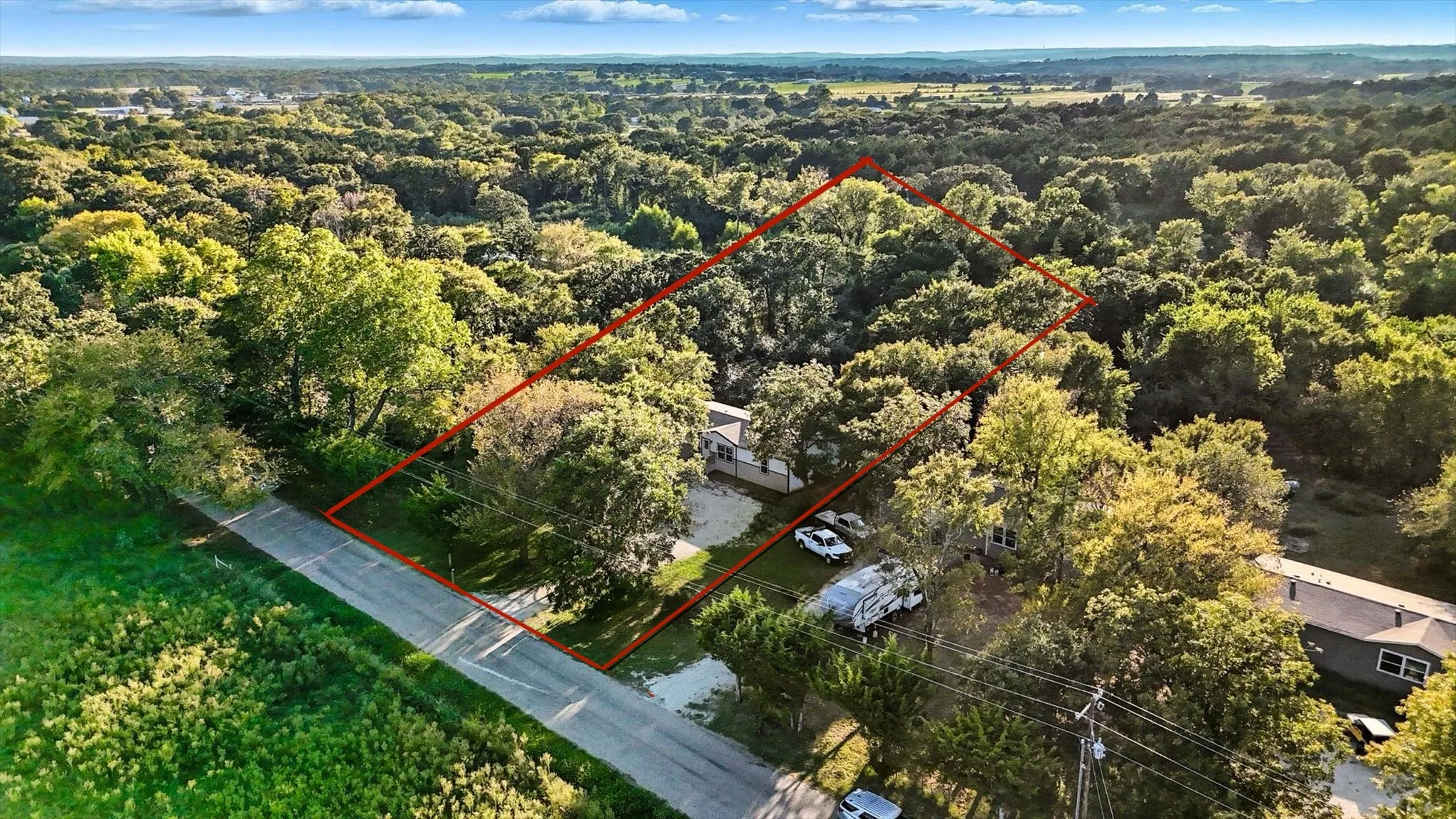Aerial overview of property's location featuring property parcel outlined and a forest