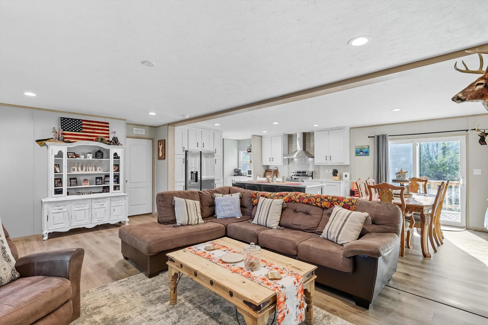 Living area with light wood-type flooring and recessed lighting