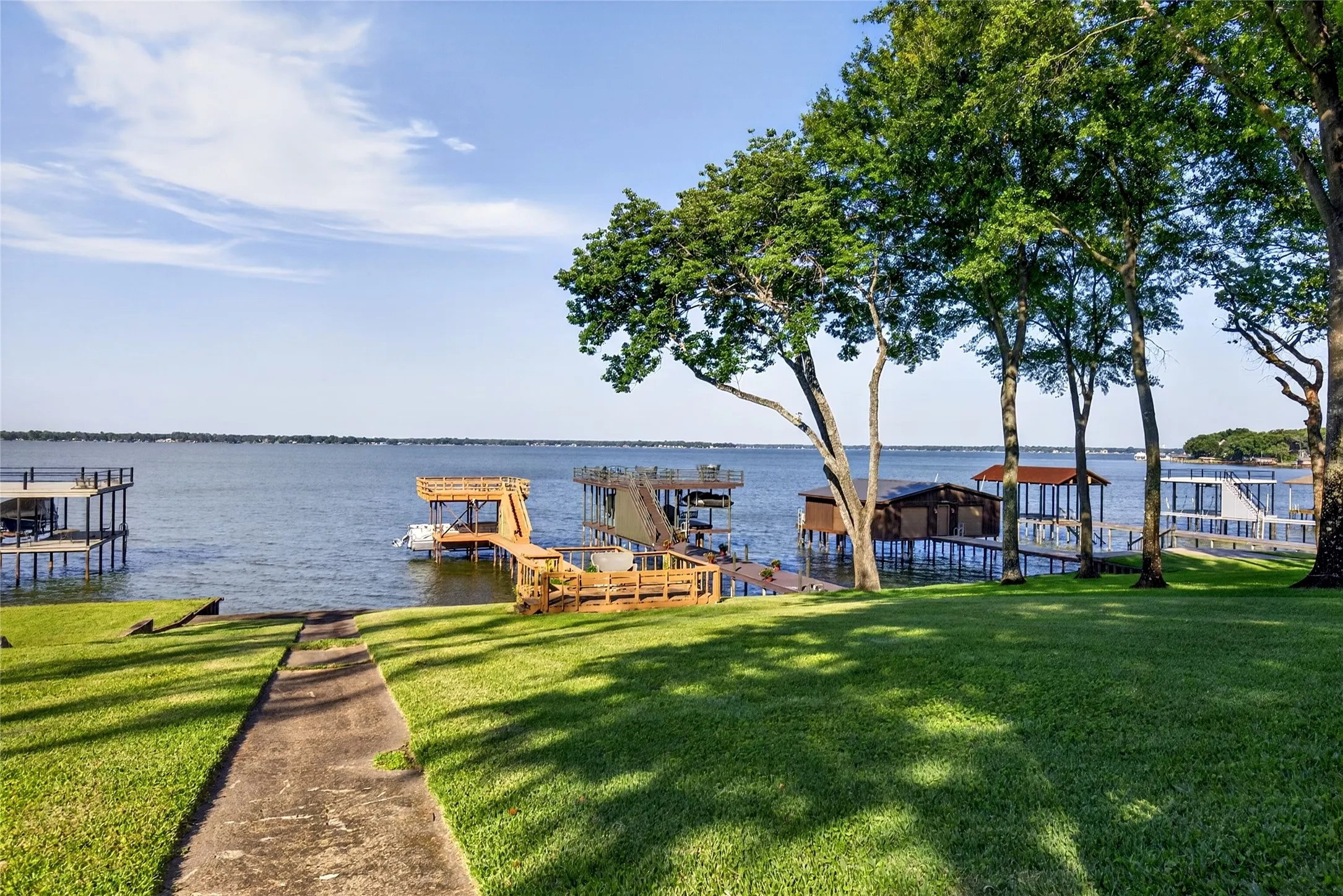Expansive waterfront property featuring Wide Open Water views with spectacular sunrise views, mature trees, a double deck boat house with a Single Pontoon slip; Main house and Cabin/Bunkhouse.  Life is Better at The Lake.