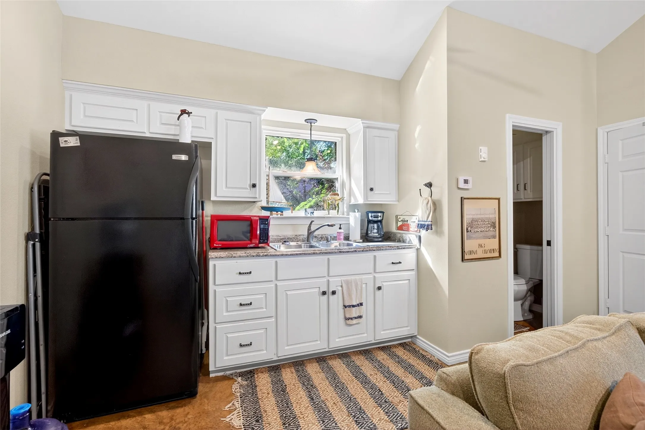 Cabin features a Compact kitchenette featuring white cabinetry, a double-basin sink, and a window with outdoor scenery.