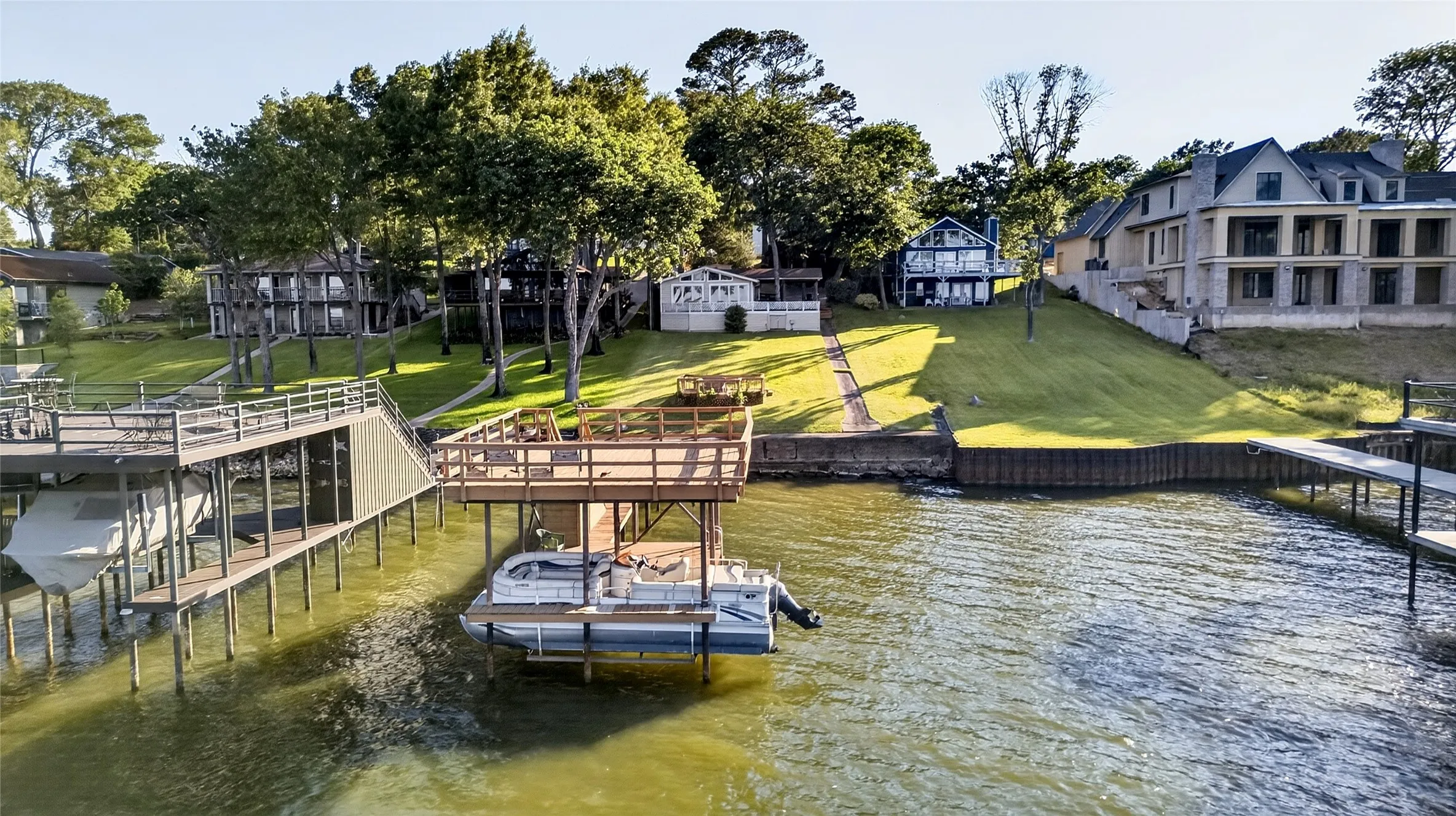Wide Open Waterfront property with a double deck boathouse, pretty mature trees, the main house 2BR/2BA which features a big covered lakeside porch, and a guest house/cabin/bunkhouse with 3 more bedrooms (1 full bath and 2 half baths).  Life is Better at the Lake!
