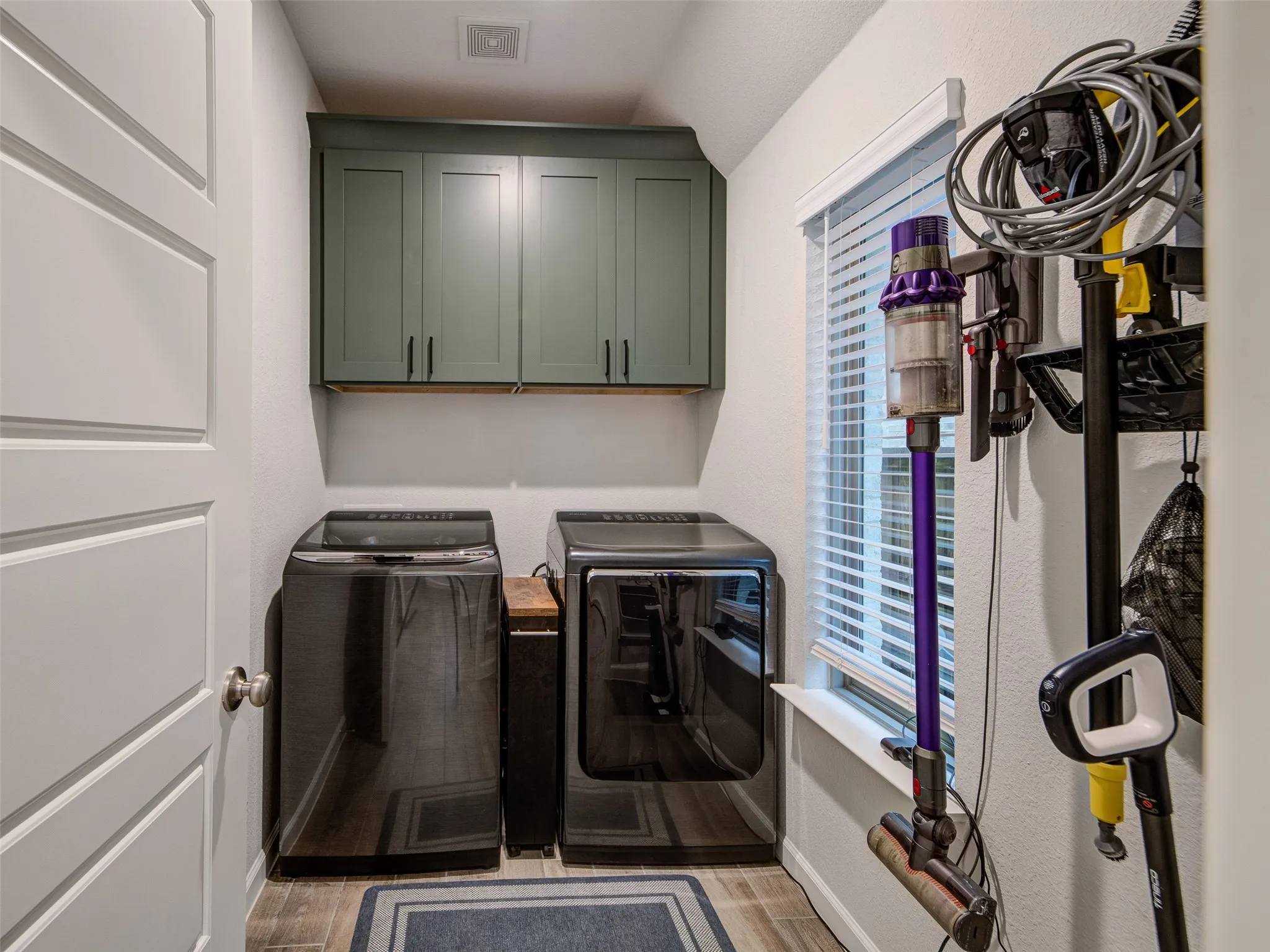 Spacious laundry room with custom soft close cabinets