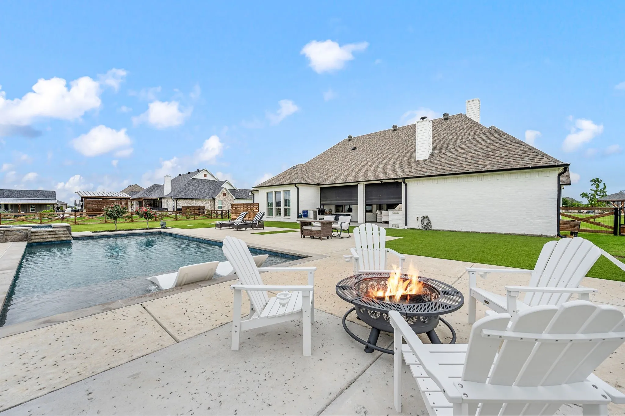 Beautiful backyard with patio shades and turf! Fire virtually enhanced
