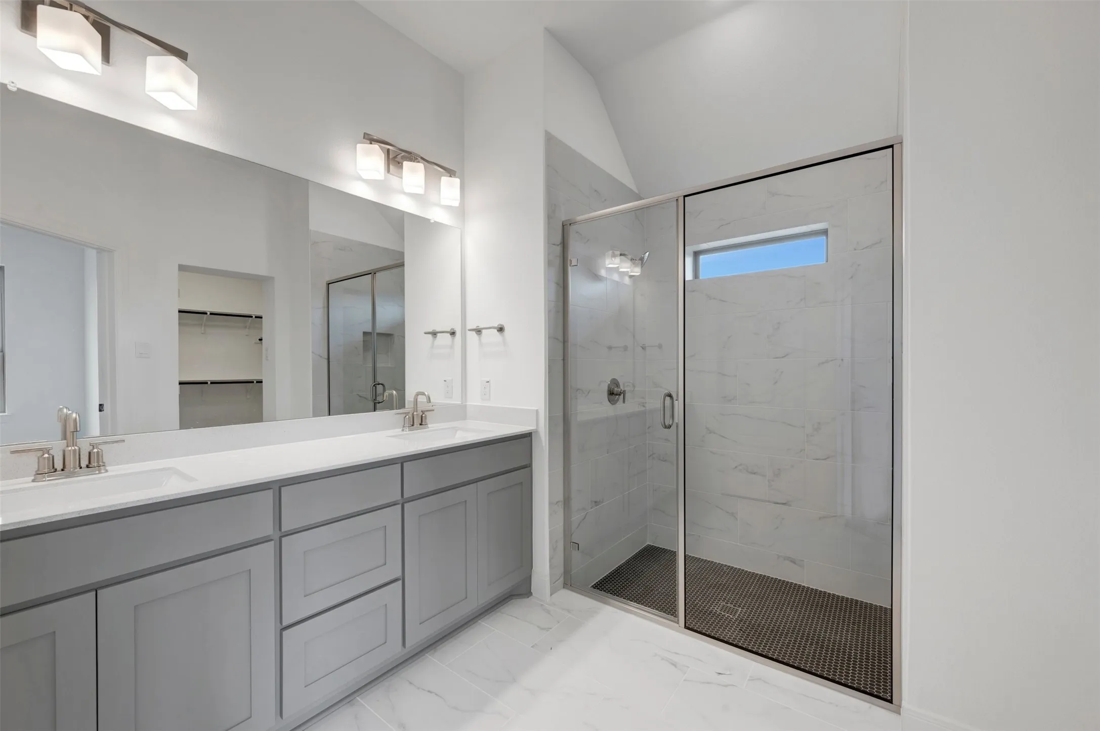 Dual vanity with light gray cabinetry, built-in sinks, and a large mirror