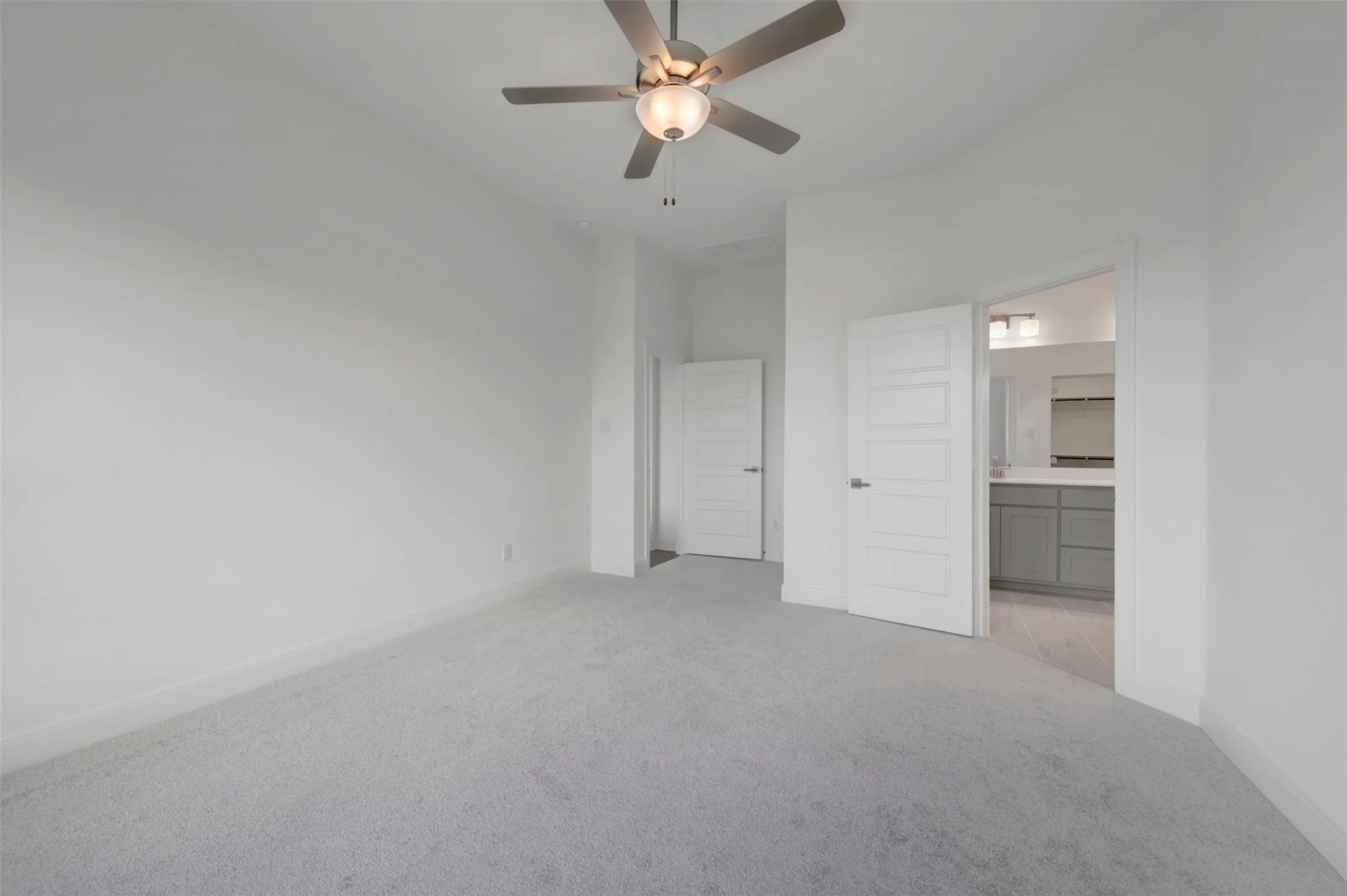 Recessed lighting, ceiling fan with light, and light-colored carpet