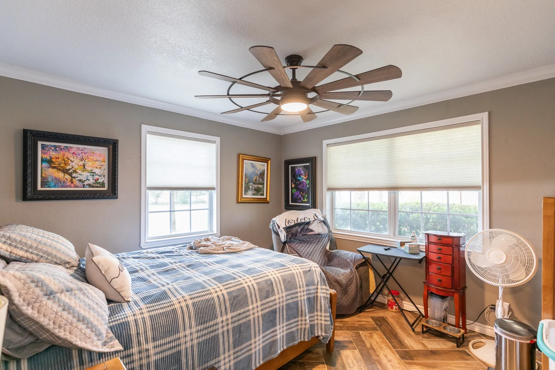 Room featuring wood-finish flooring, white window trim, and a contemporary ceiling fan