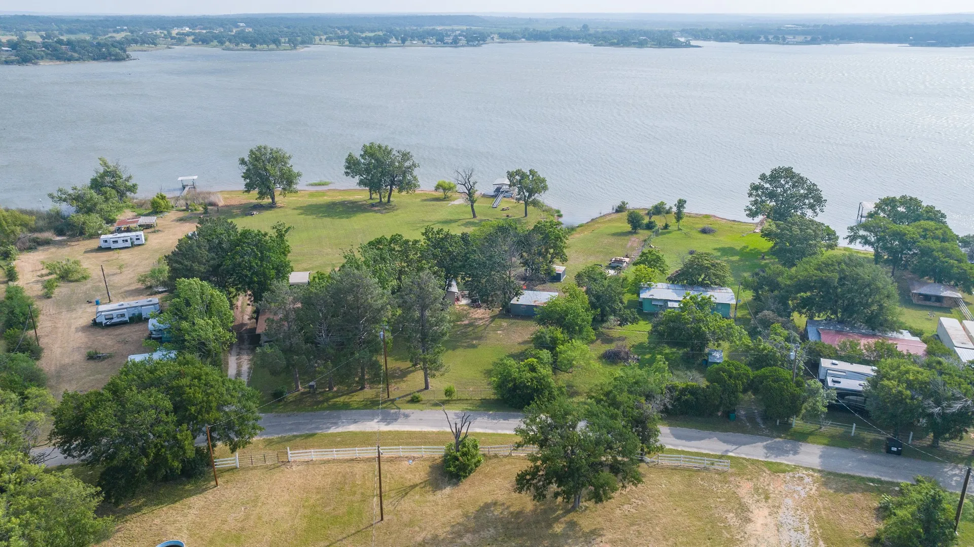 Expansive waterfront property featuring mature trees and a gently sloping landscape to the water's edge