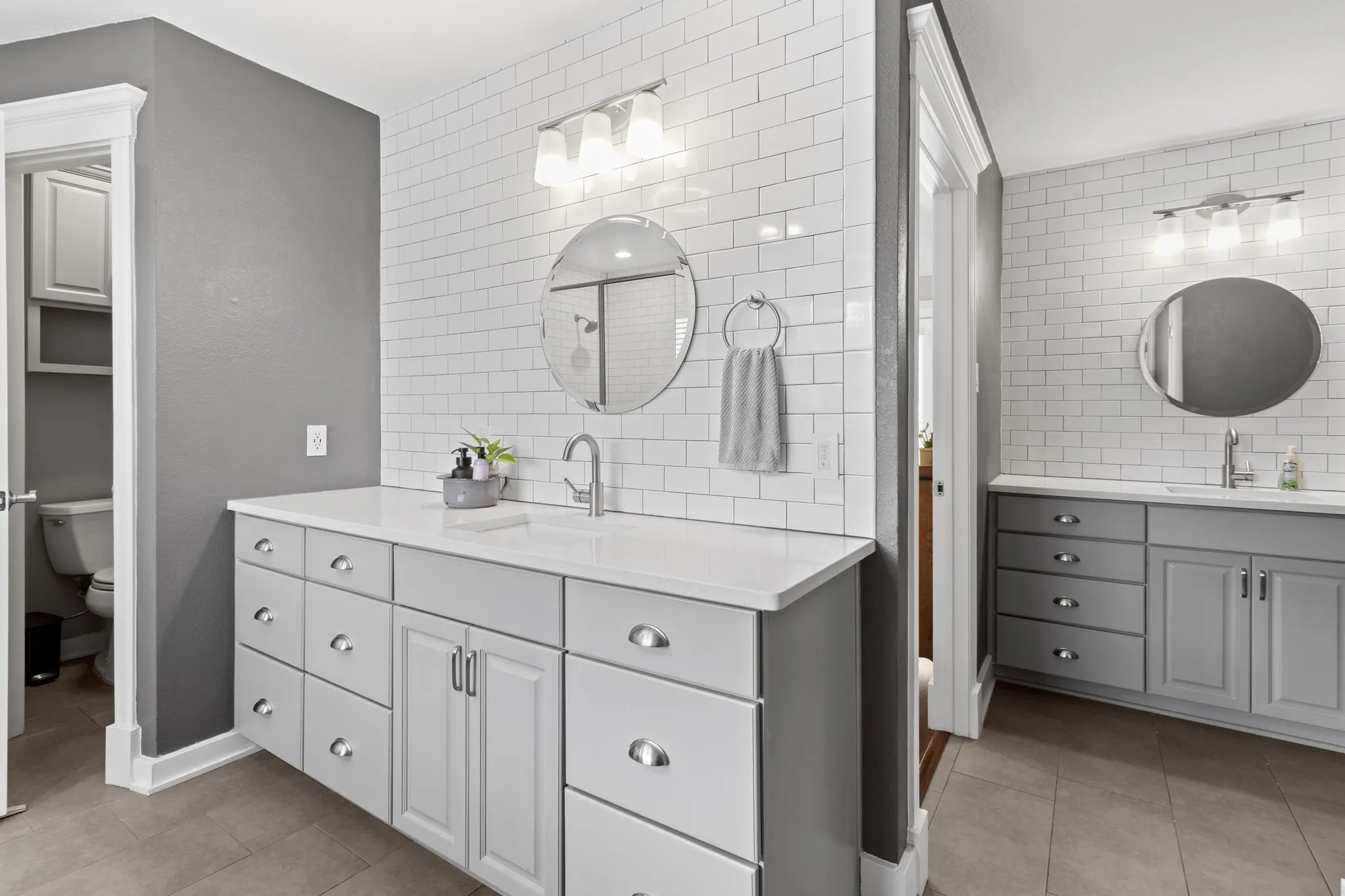 The photo depicts both vanities. Primary bathroom includes 2 toilets, 2 sinks, and 2 walk-in closets.