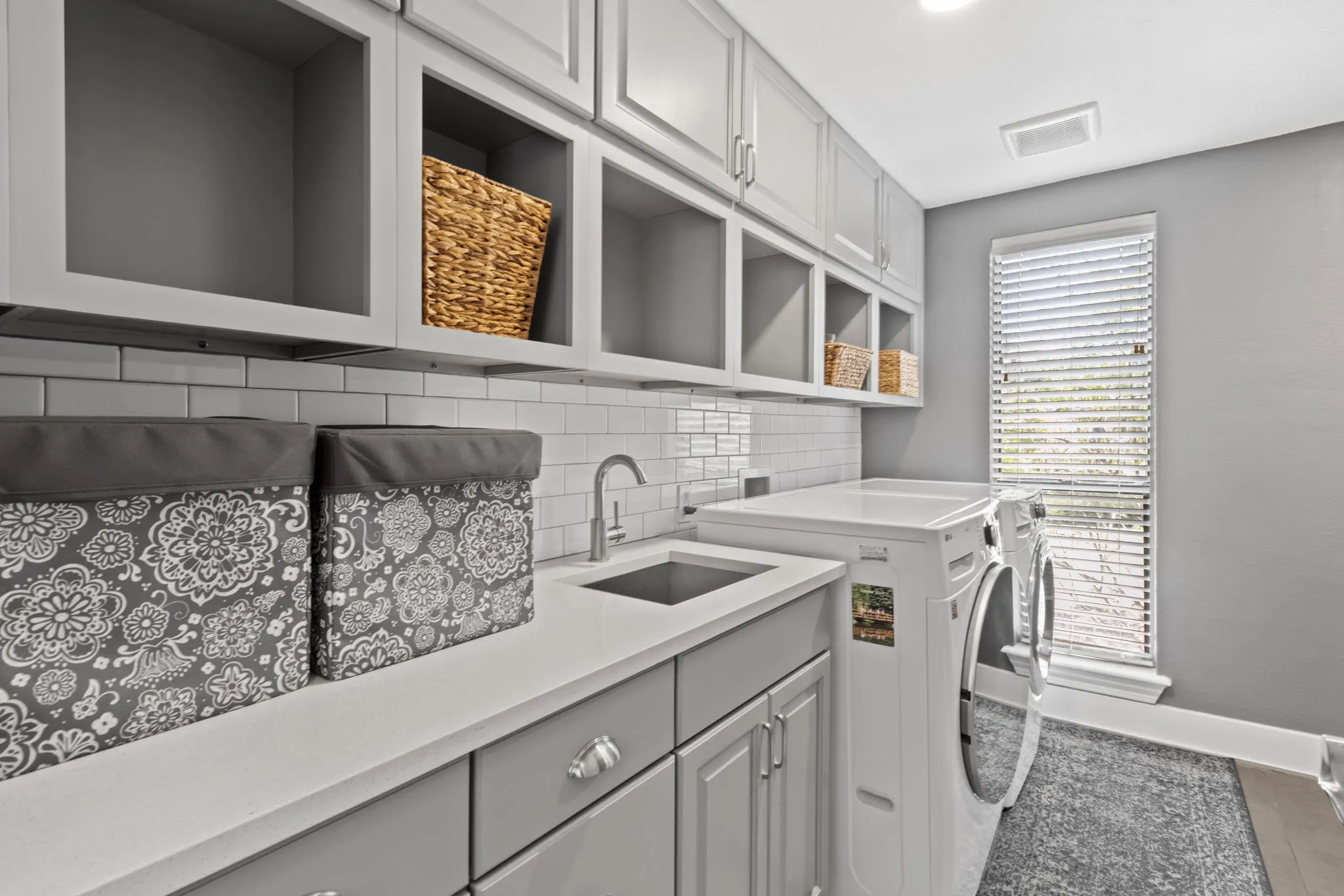 a large laundry room with a sink and a folding table (not pictured) with hanging rod