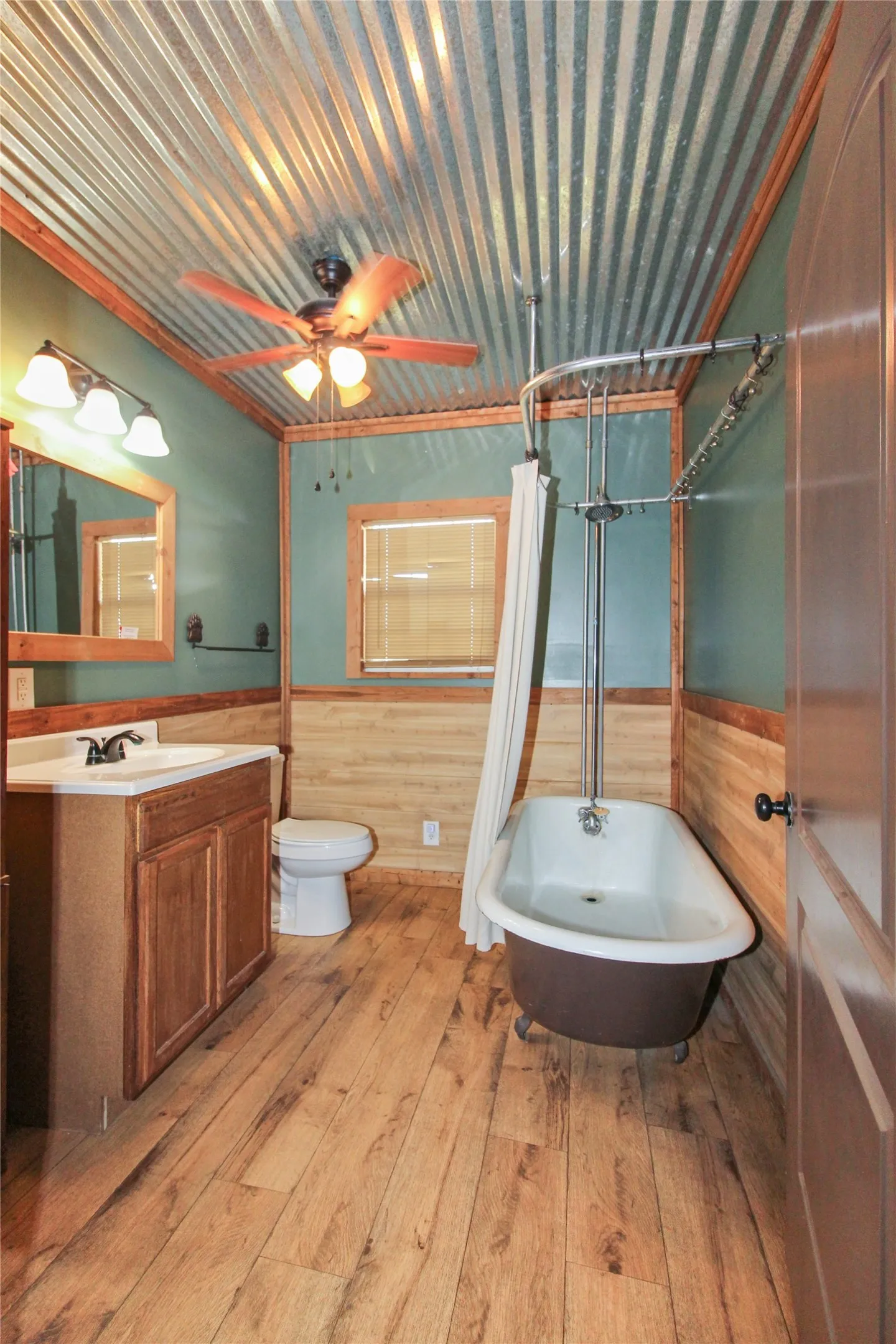 1936  HOUSE Bathroom featuring a corrugated metal ceiling, wood-finish flooring, and wood paneling on walls