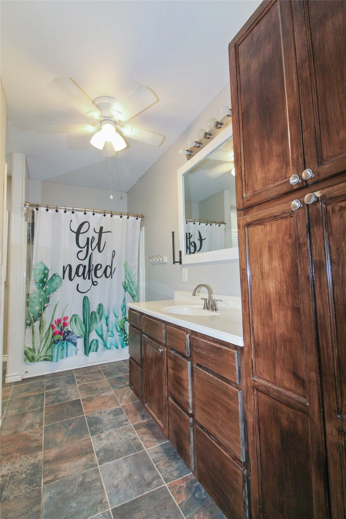 1936  HOUSE Bathroom vanity with wood-finish cabinetry, white countertop, and integrated sink