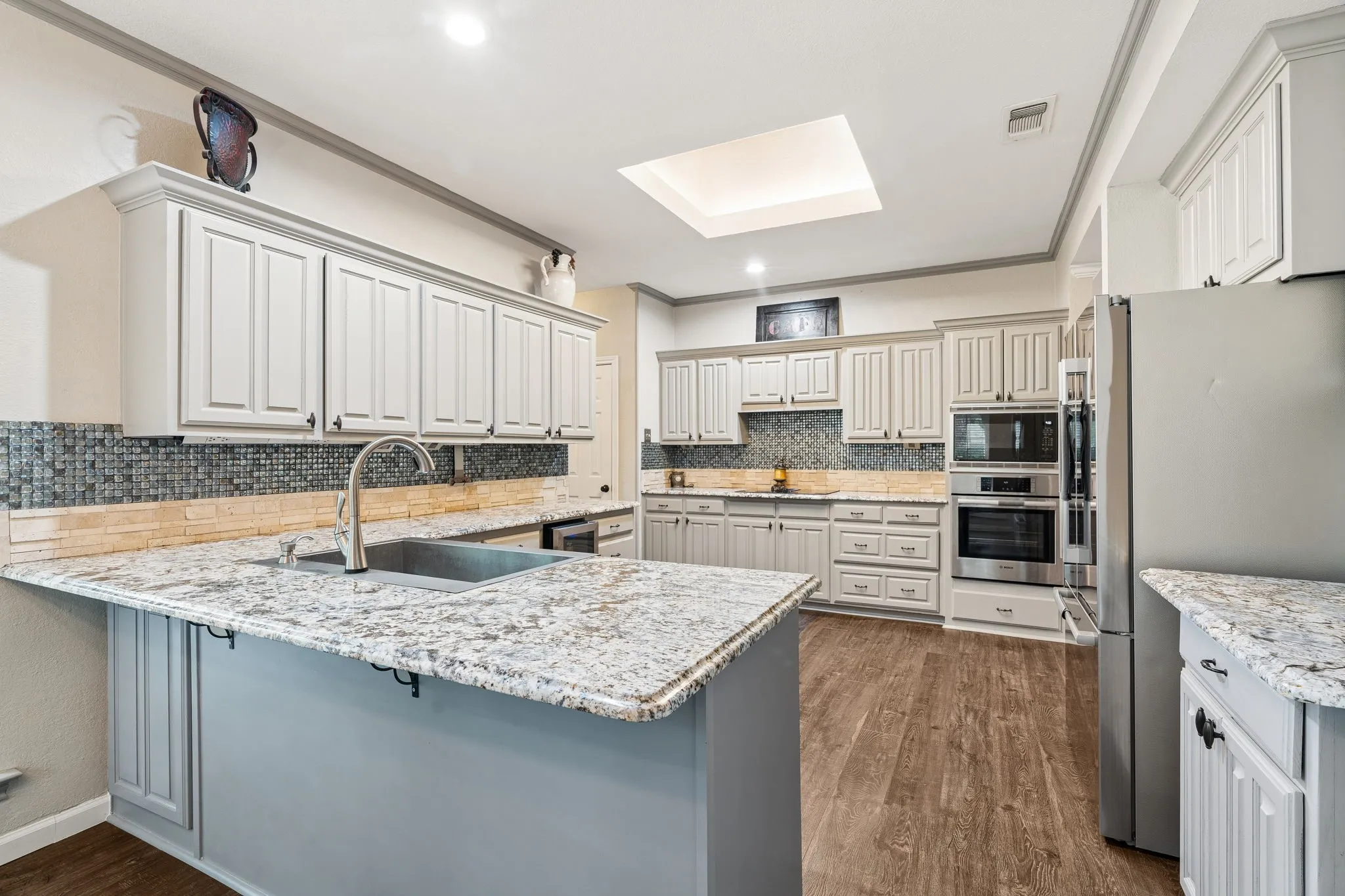 Kitchen with new appliances, countertops and features a rolling island.