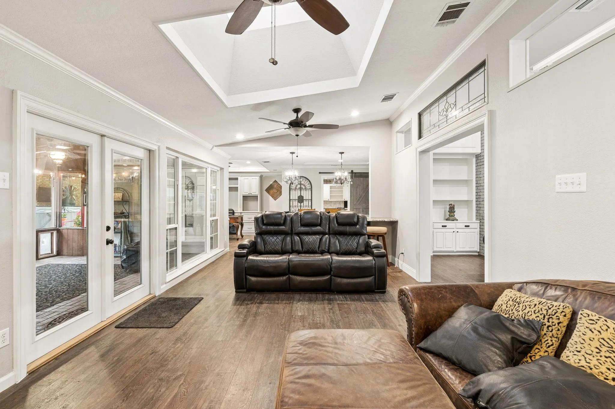 Additional living area with wall of windows viewing the screened in porch and this room features a skylight.