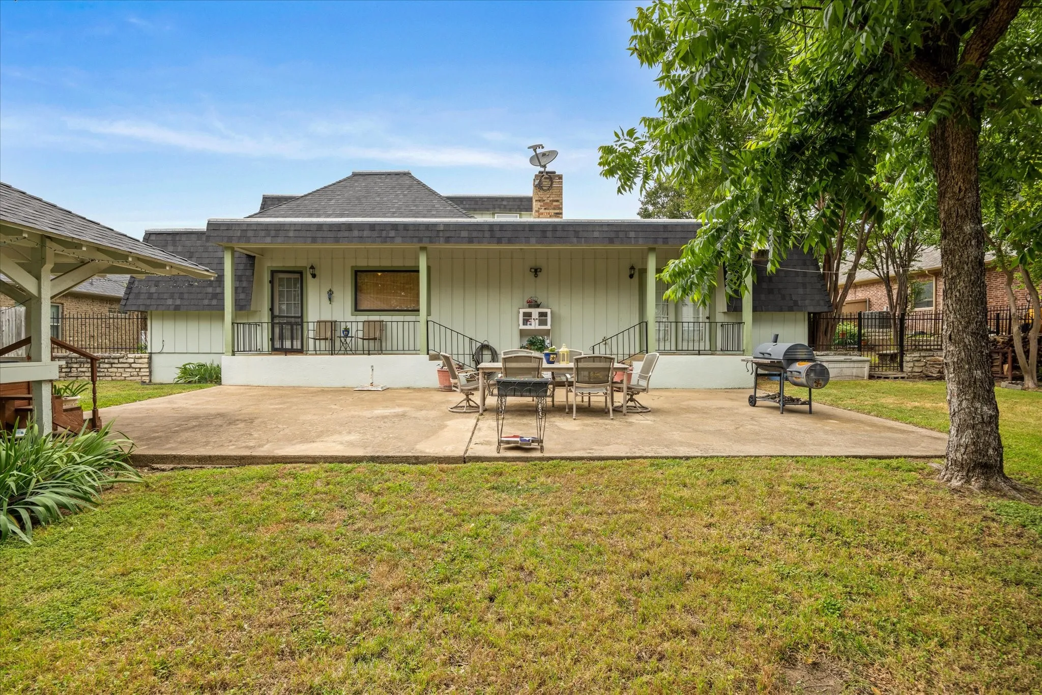 View of patio and home in backyard.