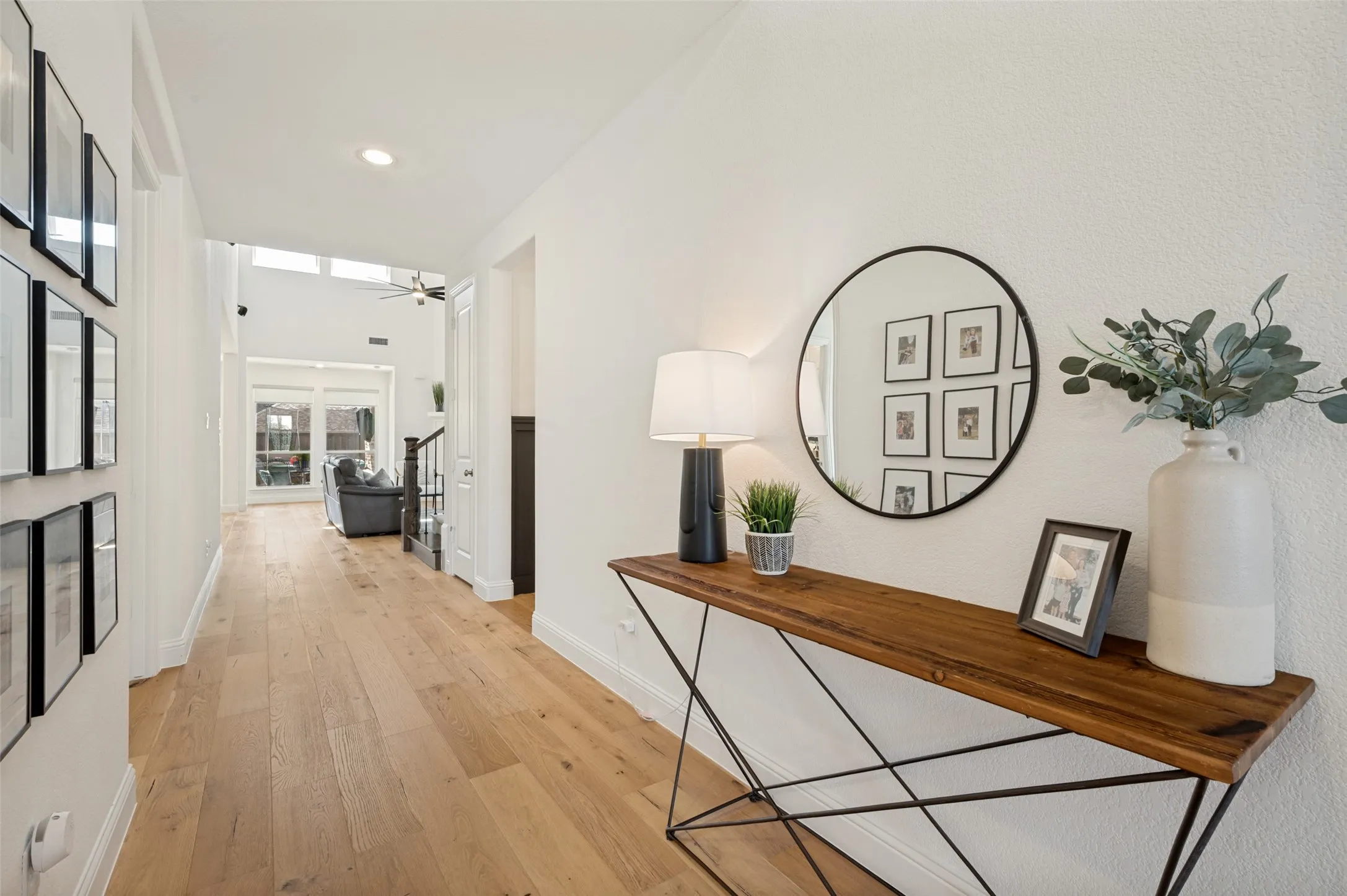 The open entryway provides visual access to the main gathering spaces with natural lighting beaming through gorgeous windows across the back wall