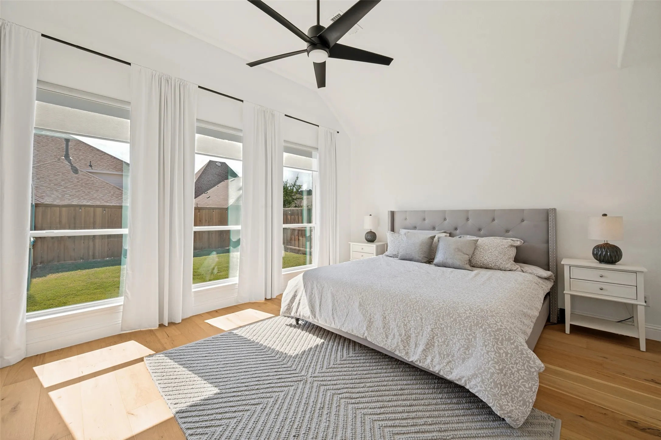 These windows stream natural light with heightened ceilings opening up this spacious primary bedroom