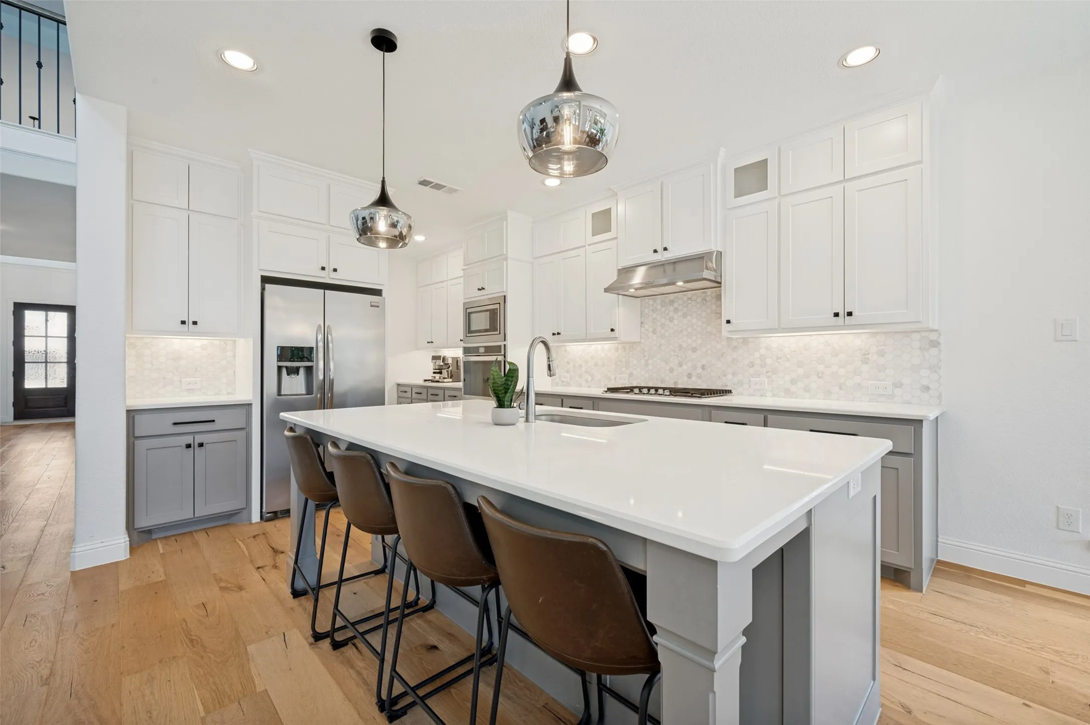 This bright kitchen is equipped with everything you need! From white counter tops and neutral cabinets with oversized island and stainless steel appliances, it is a room both functionally and visually appealing