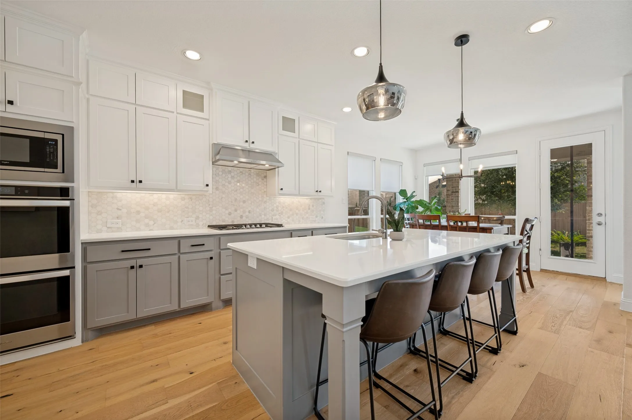 With trending backsplash, neutral tones, light counter tops and ample storage space, this culinary space is sure to please from everyday routine to entertaining on the weekends!