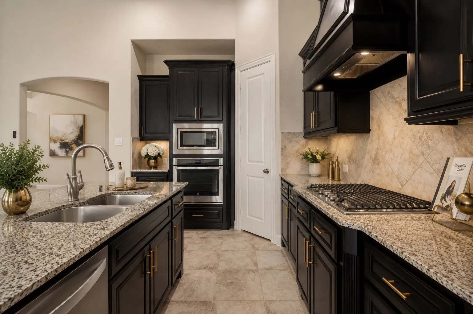 Gourmet kitchen with black cabinetry, granite countertops, stainless steel appliances, and a gas cooktop