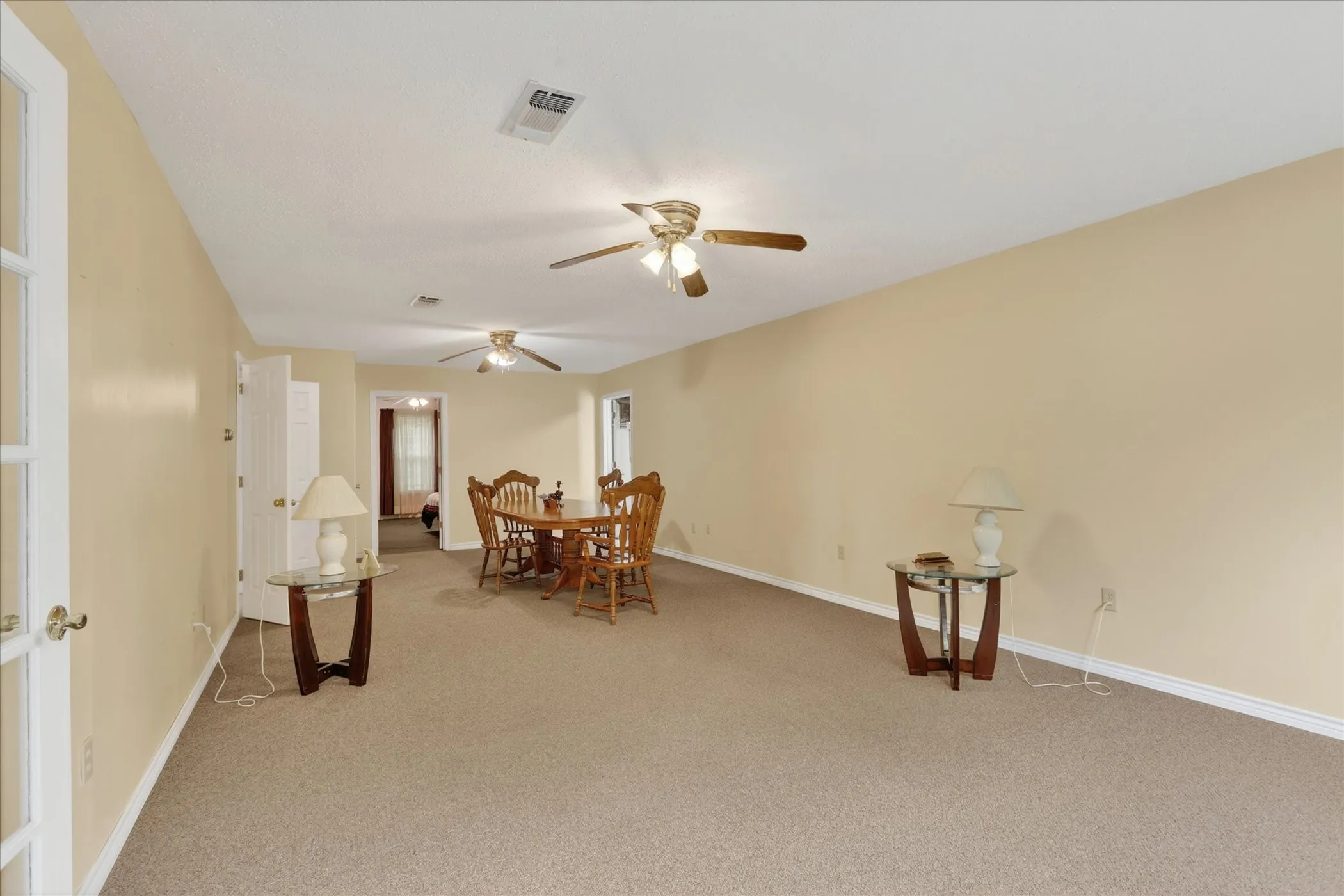Spacious living area featuring neutral carpet flooring and light-toned walls