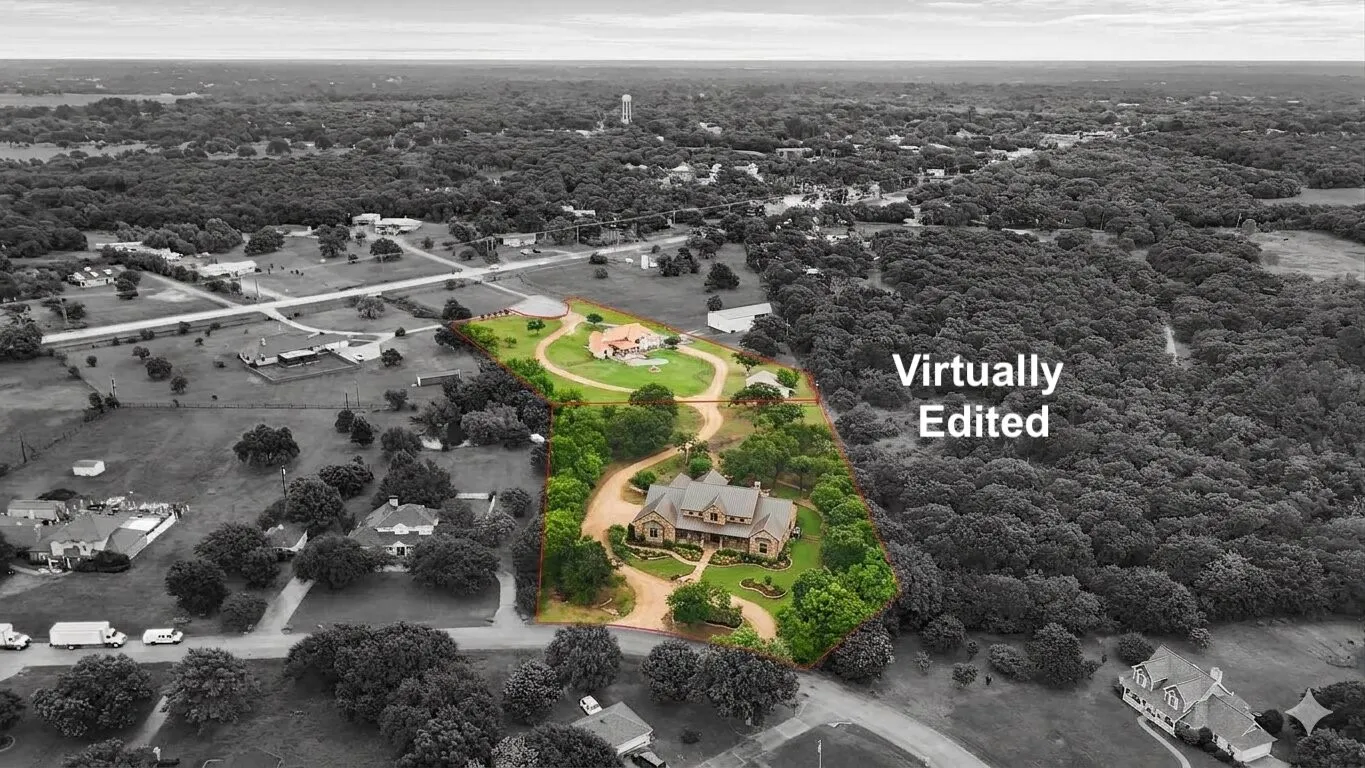 Aerial perspective showcasing a sprawling property outlined in red, featuring two distinct residences surrounded by extensive green landscaping