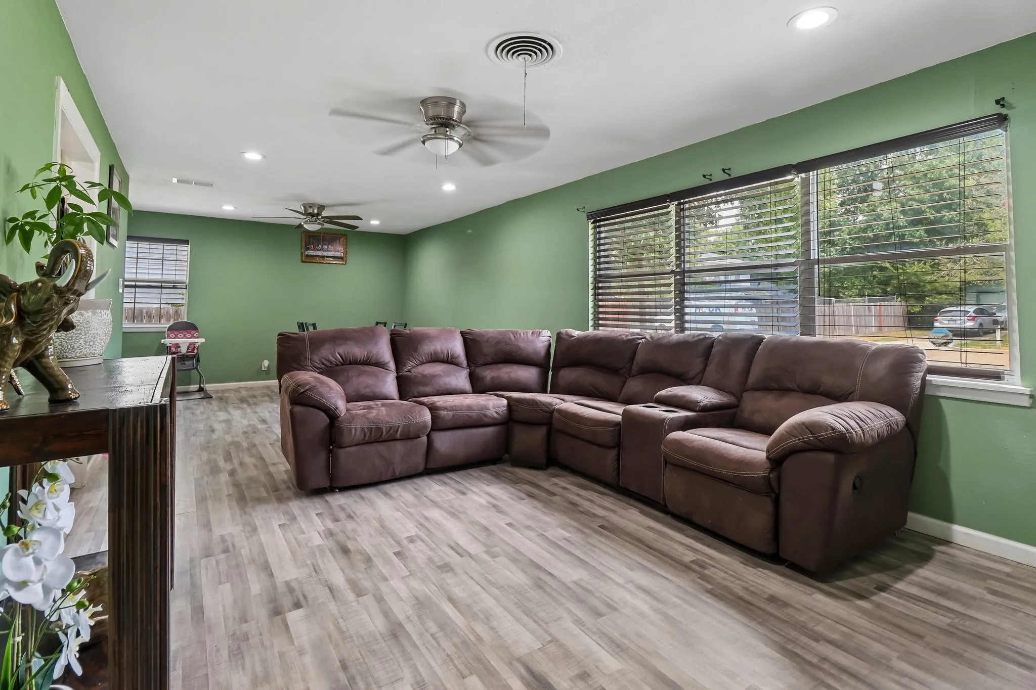 Spacious room featuring wood-finish flooring, recessed lighting, and multiple windows with blinds