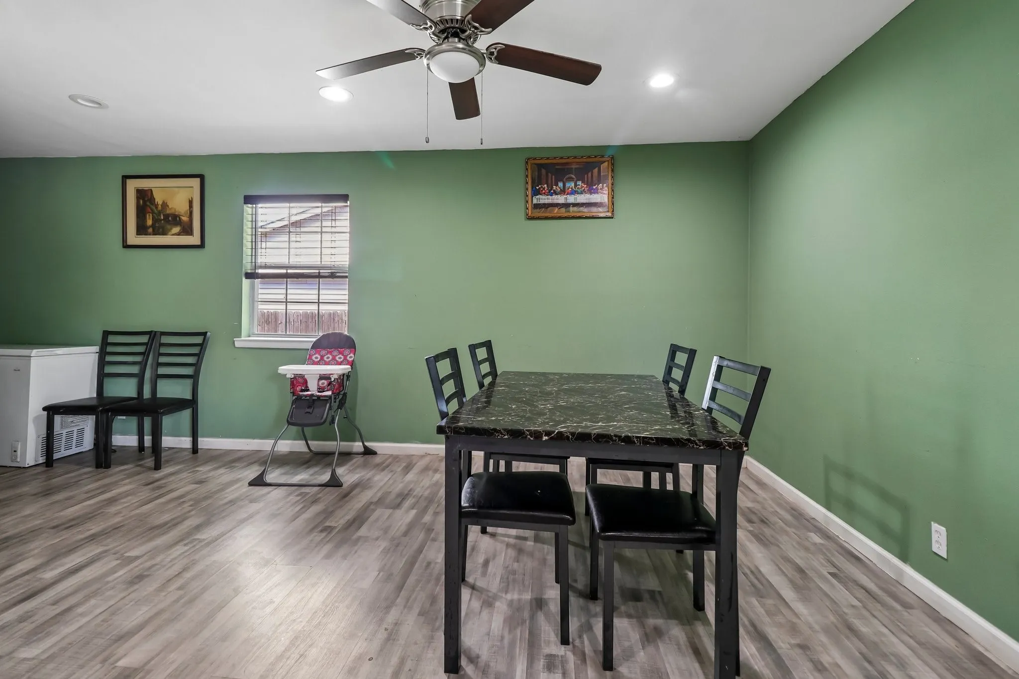 Wood-finish flooring with a ceiling fan, recessed lighting, and a window with blinds