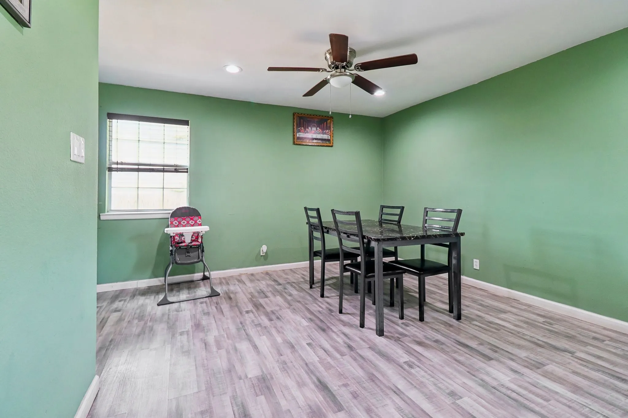 Wood-finish flooring with a ceiling fan light fixture and recessed lighting